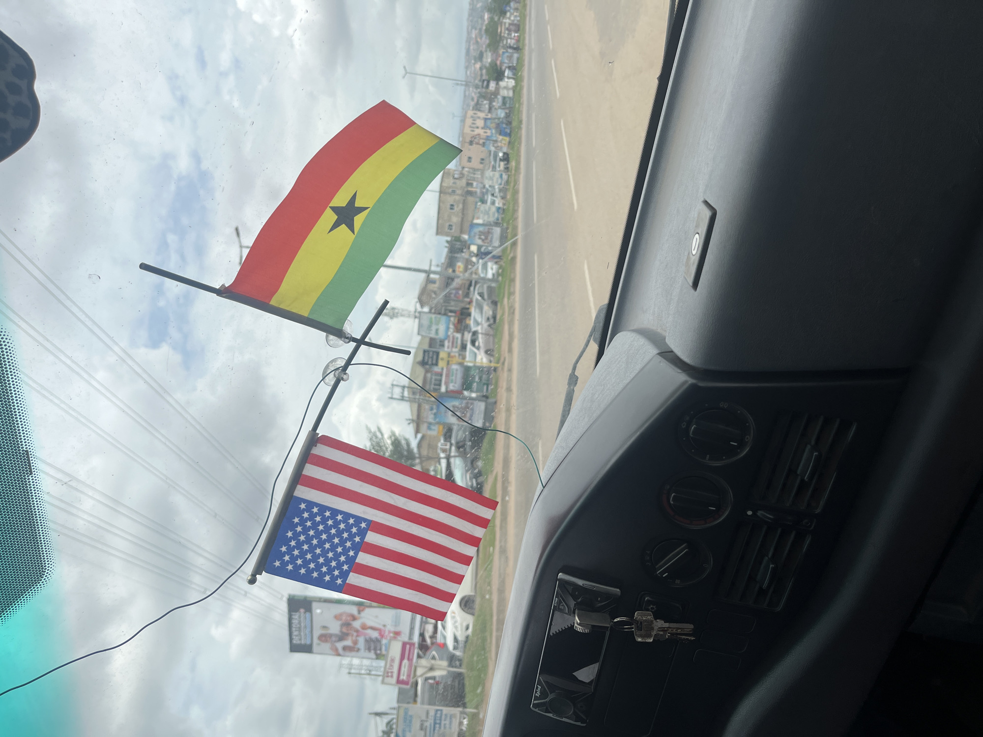 Vehicle interior captured with flags on windshield in Ablekuma