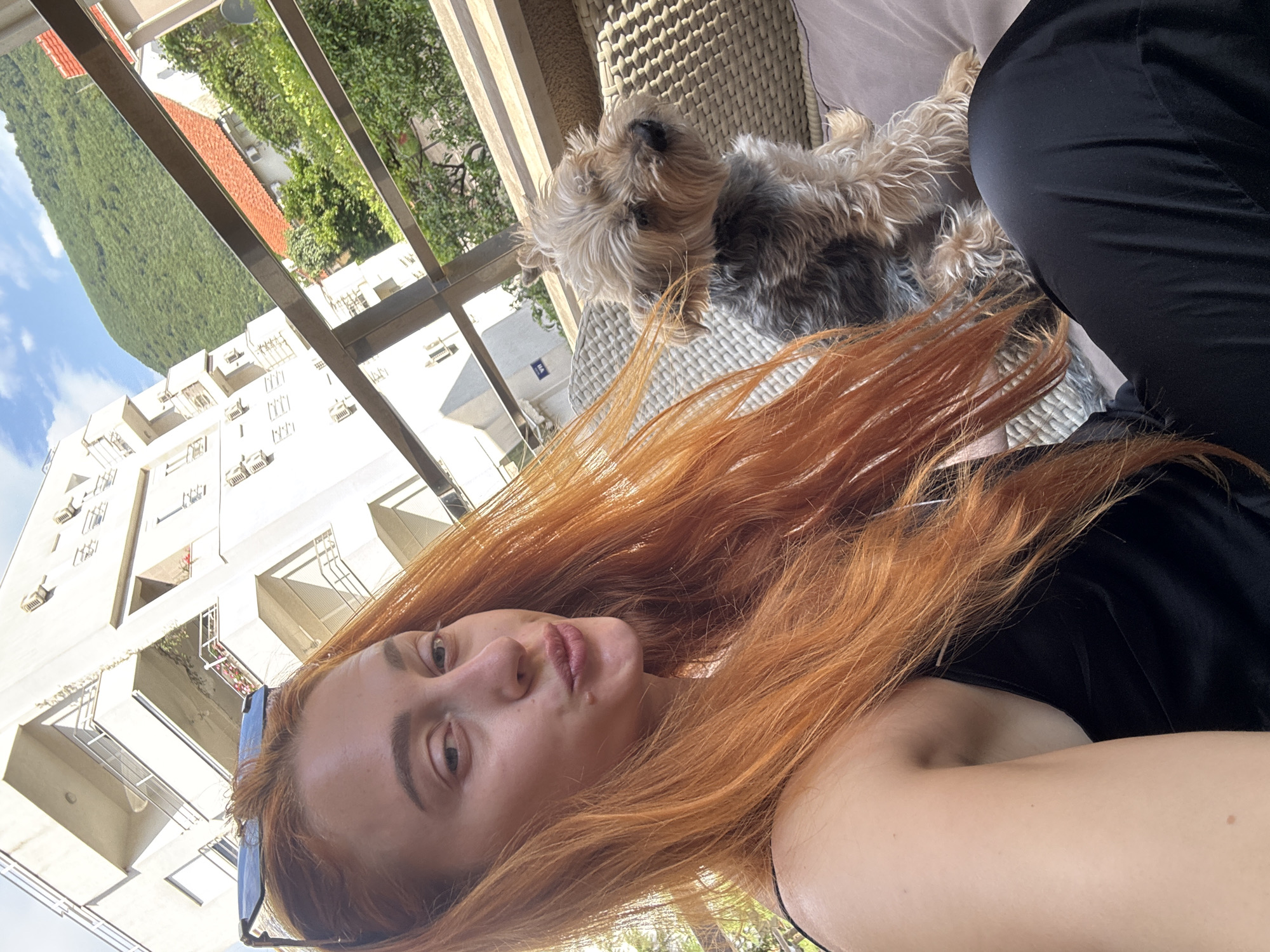 Woman and Yorkshire Terrier enjoy morning on Budva balcony