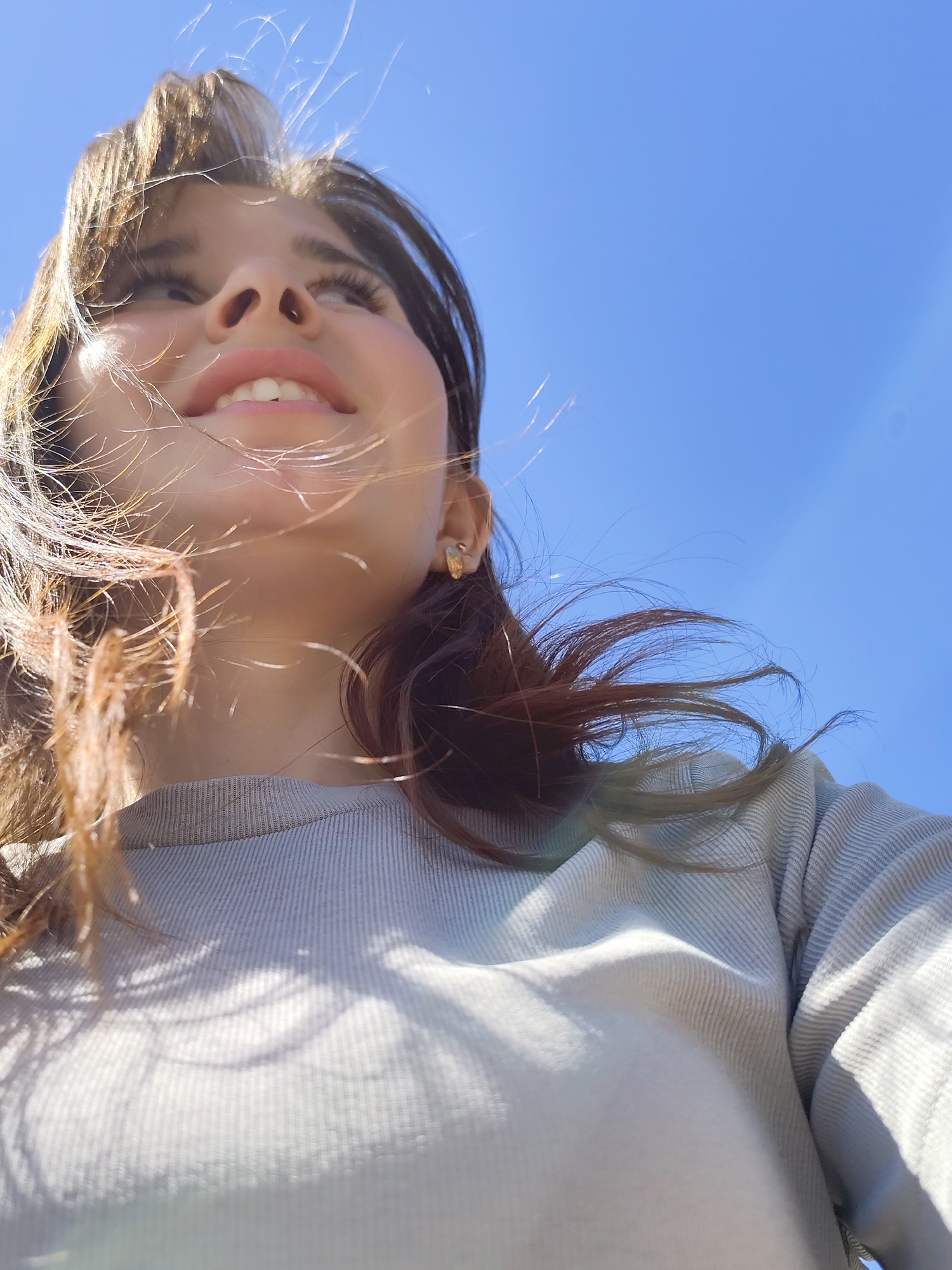 Woman gazes skyward by lake in windy morning, Фоки Russia