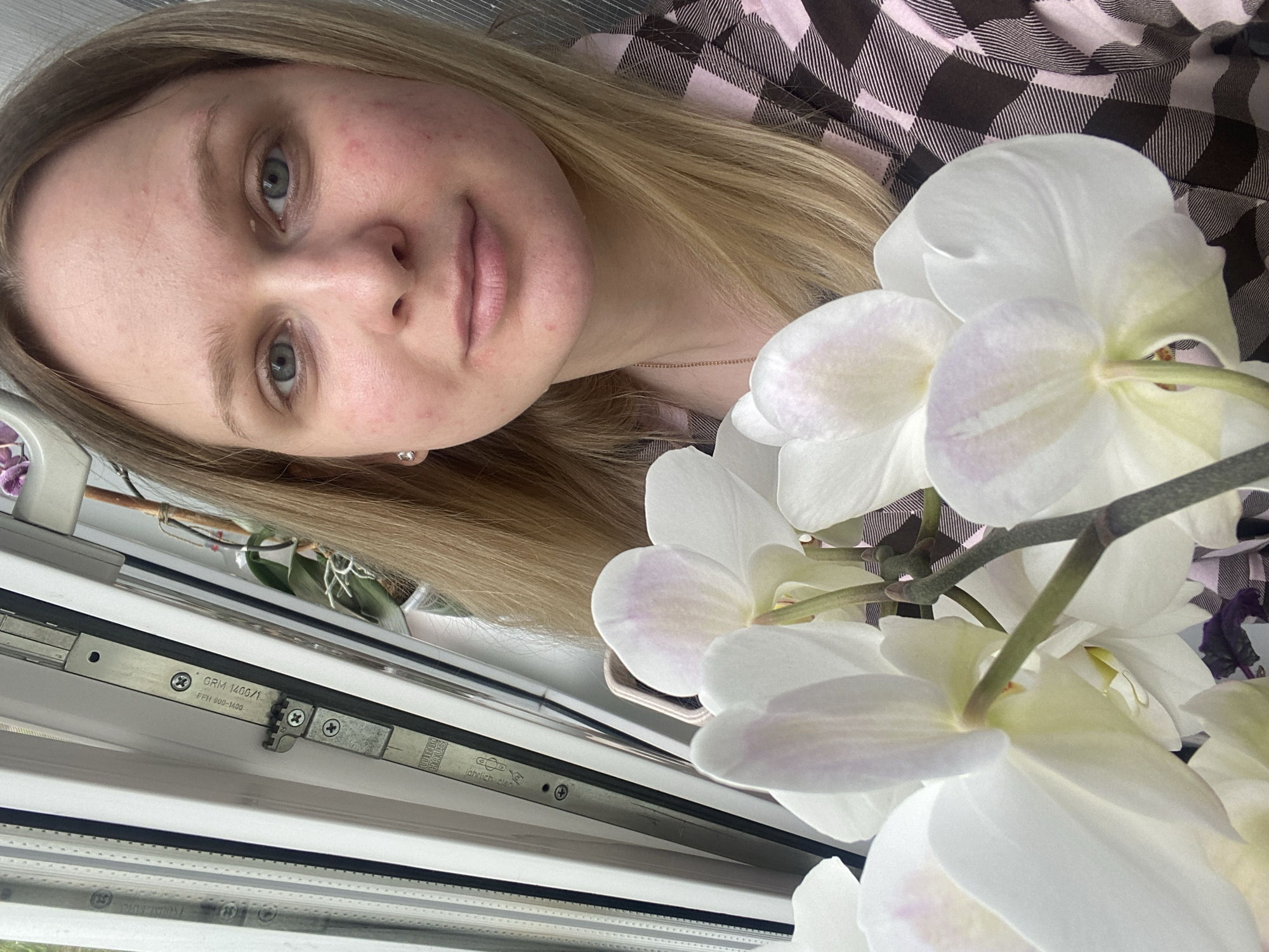 Woman poses with orchids in Russian home