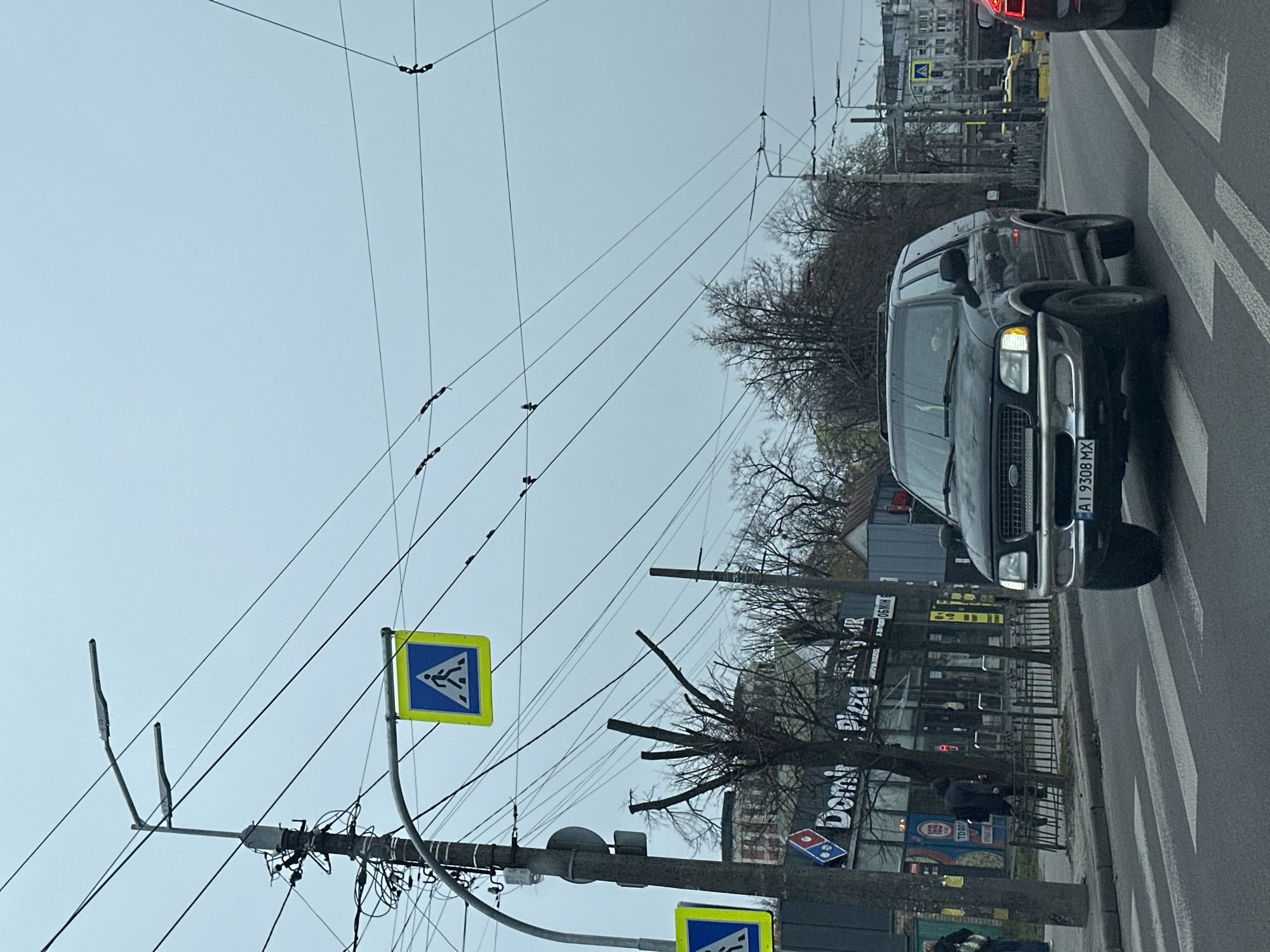 Black Ford SUV crosses zebra crossing in early morning Kyiv