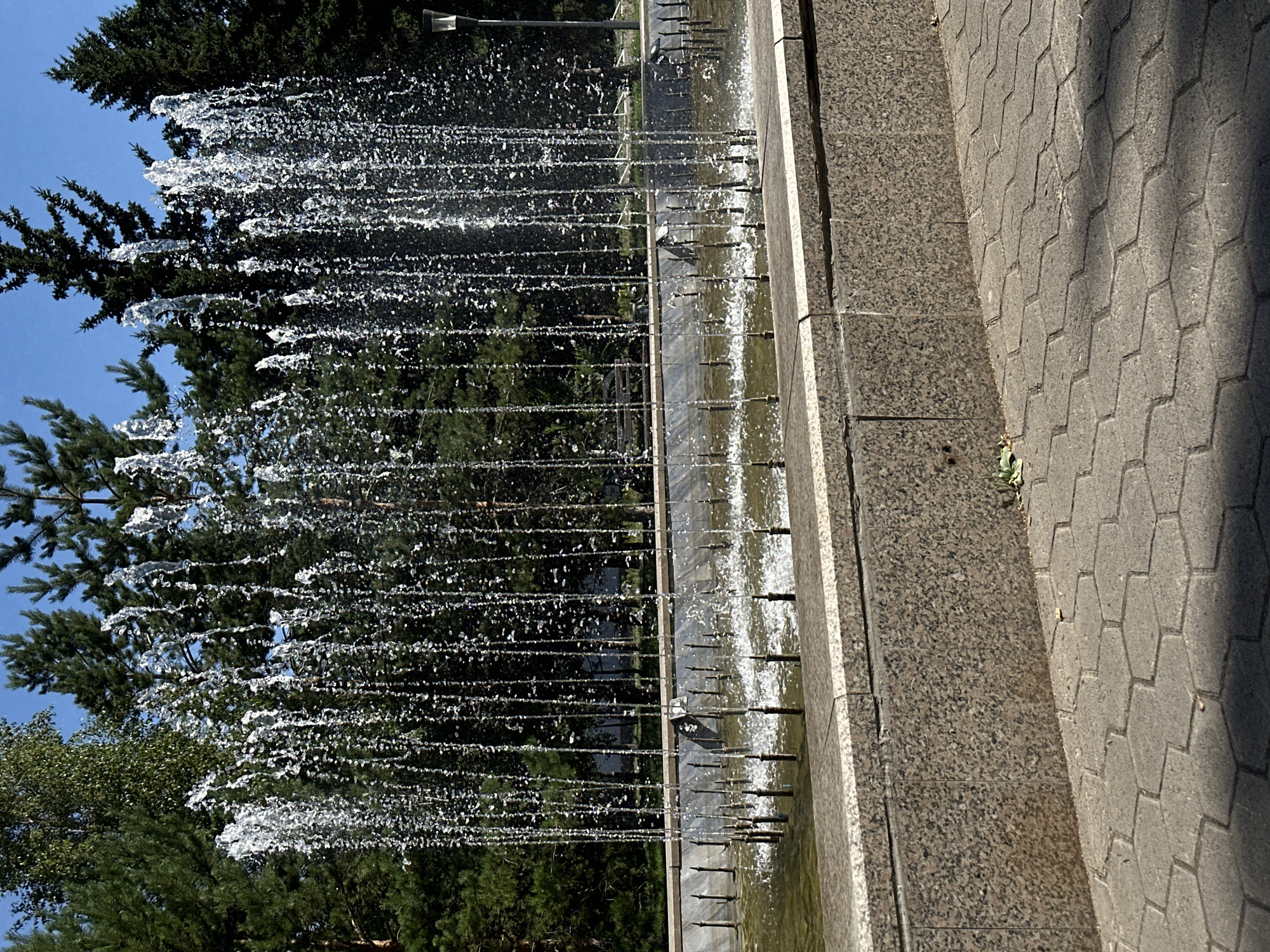 Sunny morning at a Kokshetau park fountain and walkways