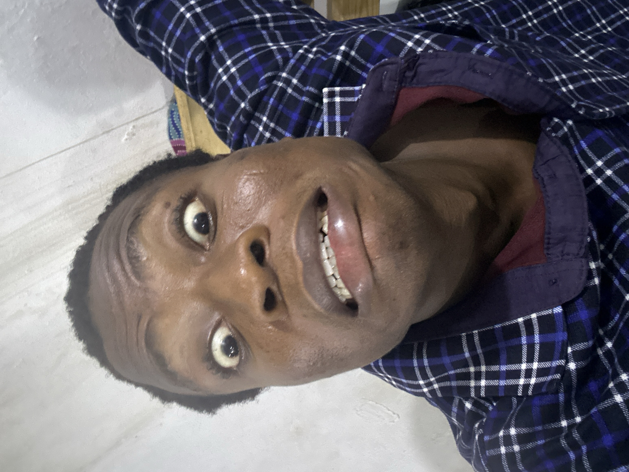 Person in plaid shirt observed lying on white surface