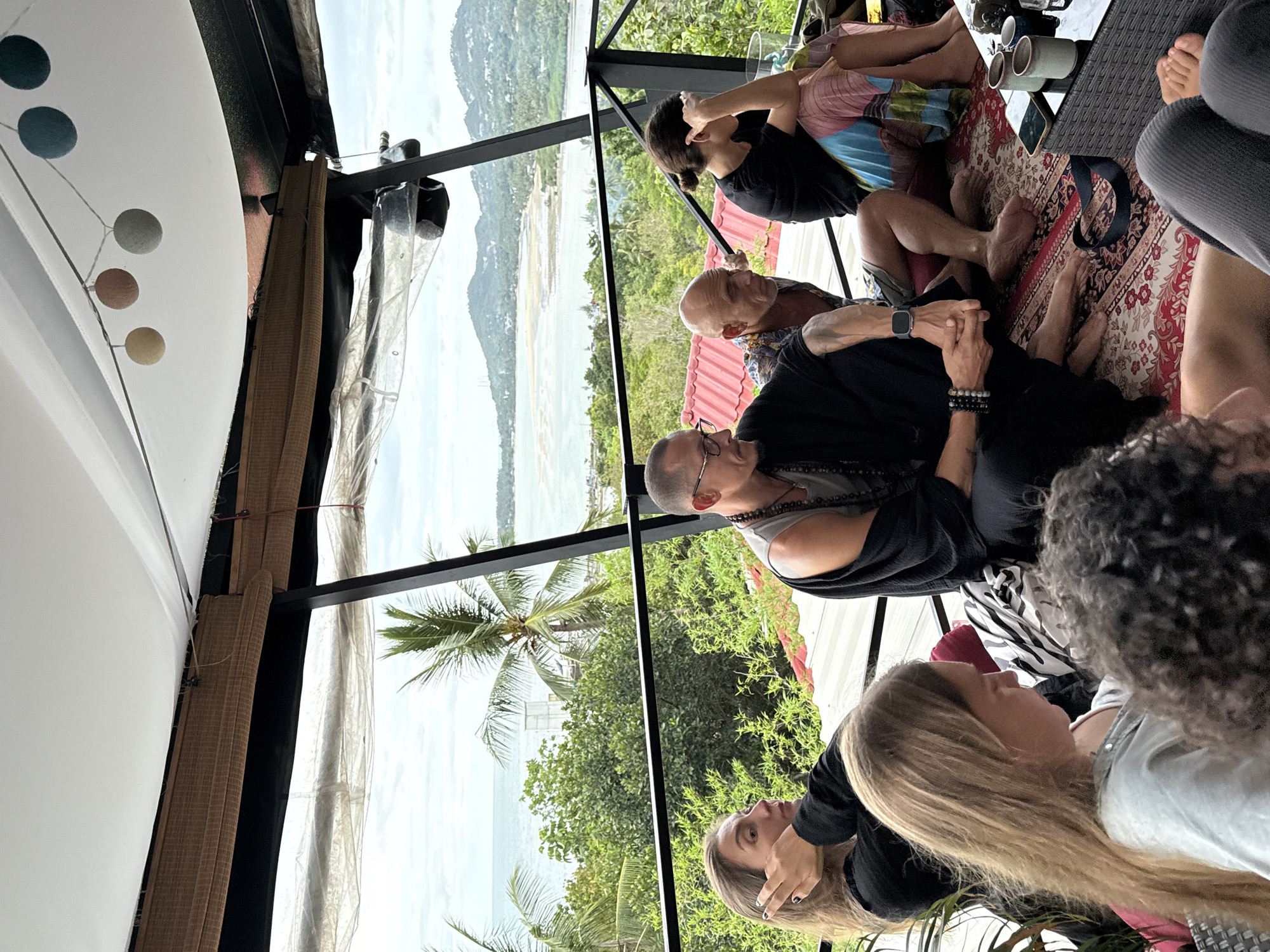Group gathers on Ko Phangan patio overlooking coast