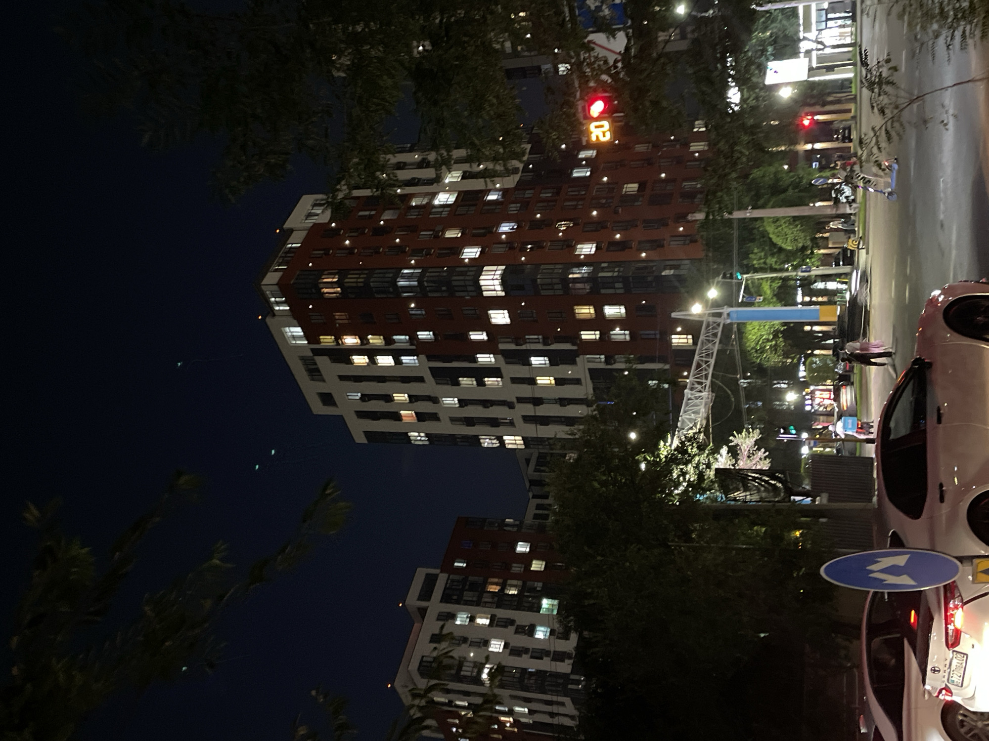 Nighttime street scene with parked bus near Almaty apartment blocks
