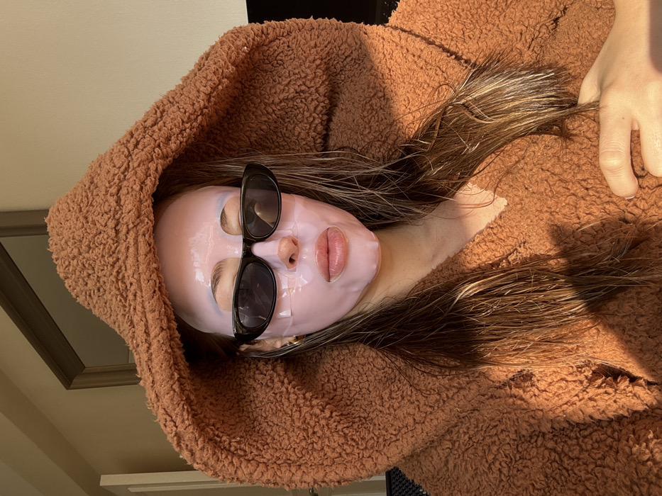 Woman in pink sheet mask documented indoors