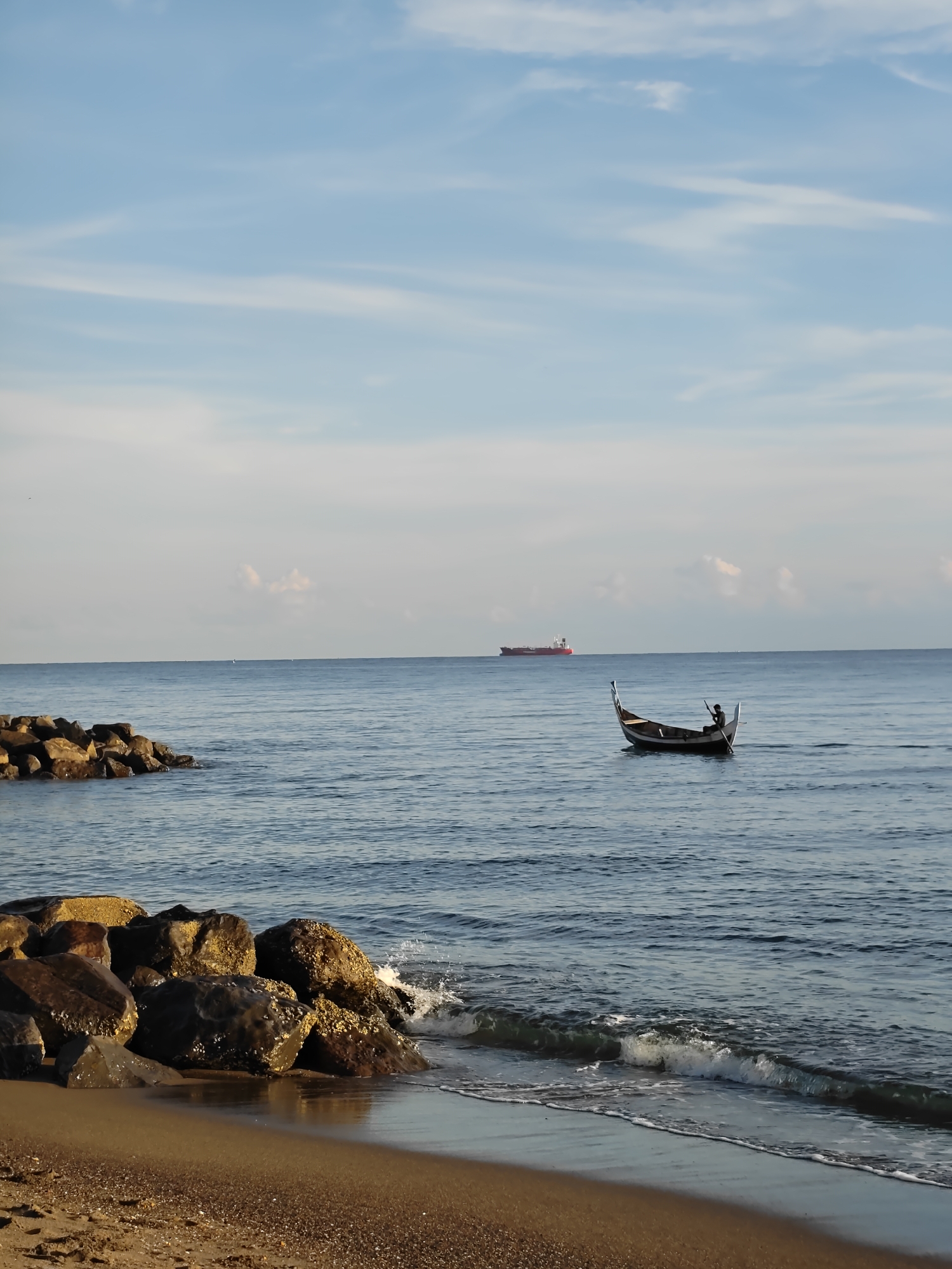 Fisherman rows traditional boat near Lhokseumawe coast