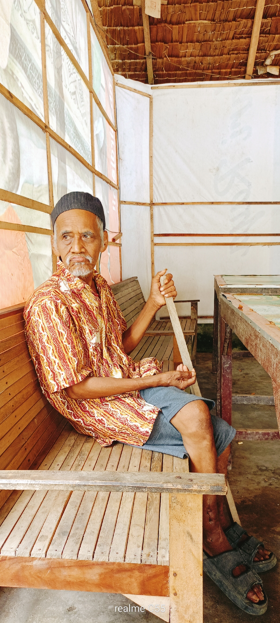 Backyard scenes in Lhokseumawe: bench rest, goats, and a centipede