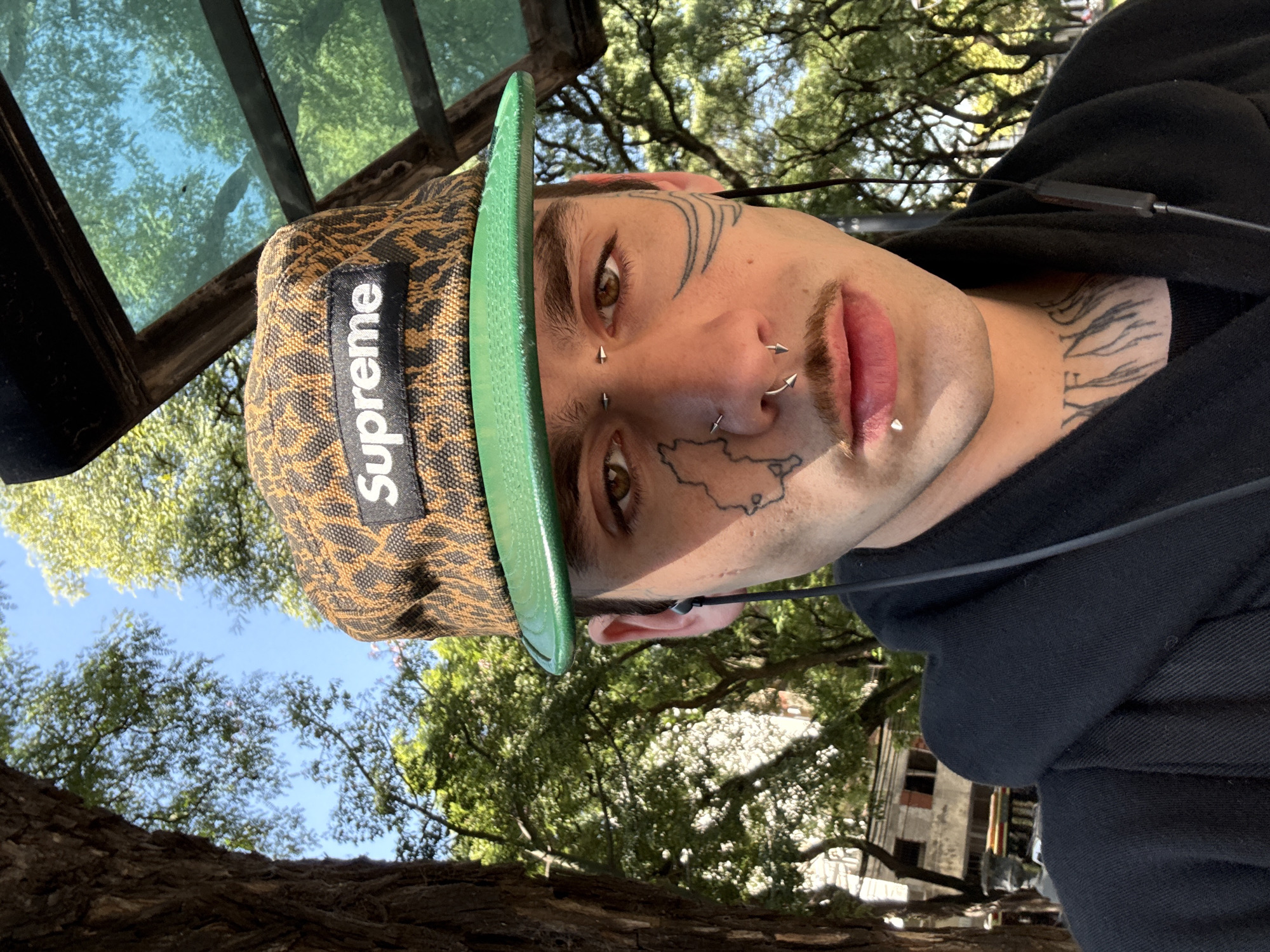 Person with facial piercings spotted wearing Supreme cap in Buenos Aires