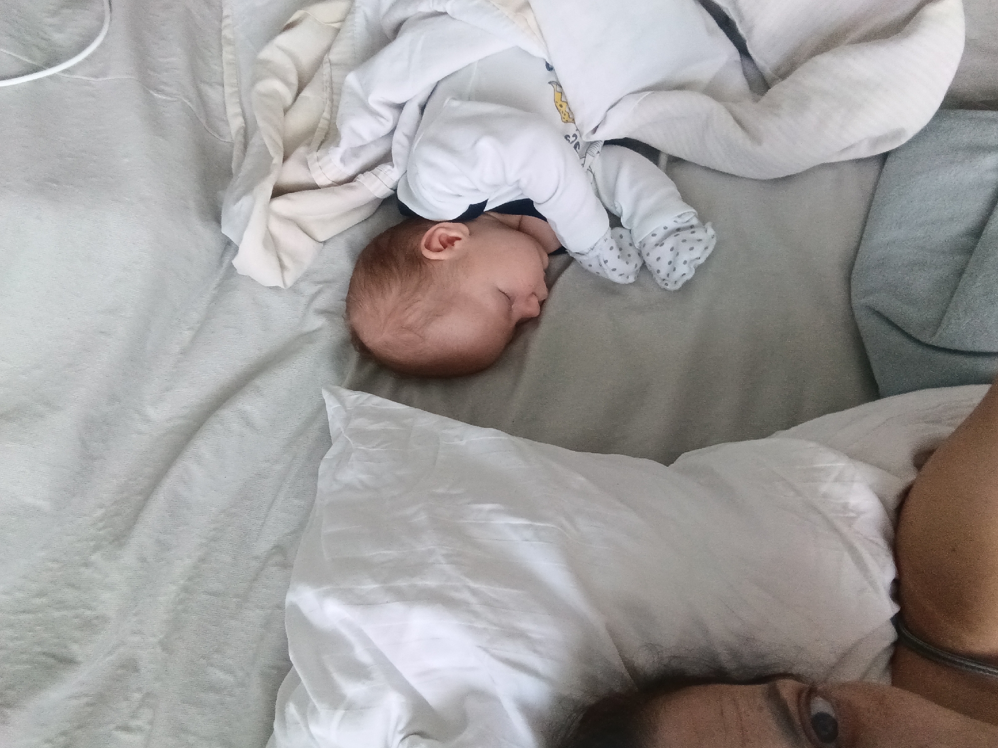 Baby sleeps peacefully beside guardian in Andreyevo home