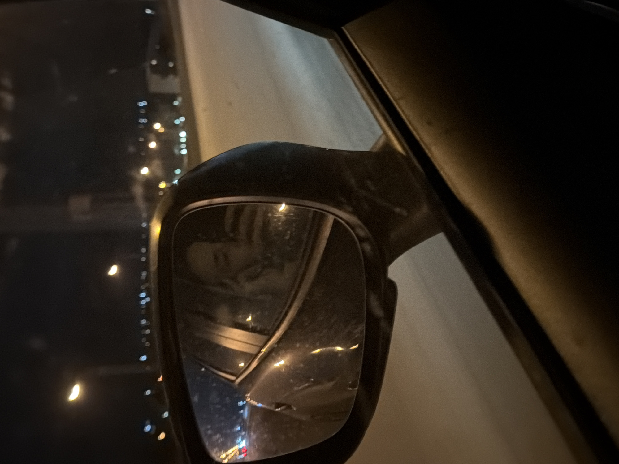 Rainy night cityscape reflected in car mirror, Chaikovsky Russia