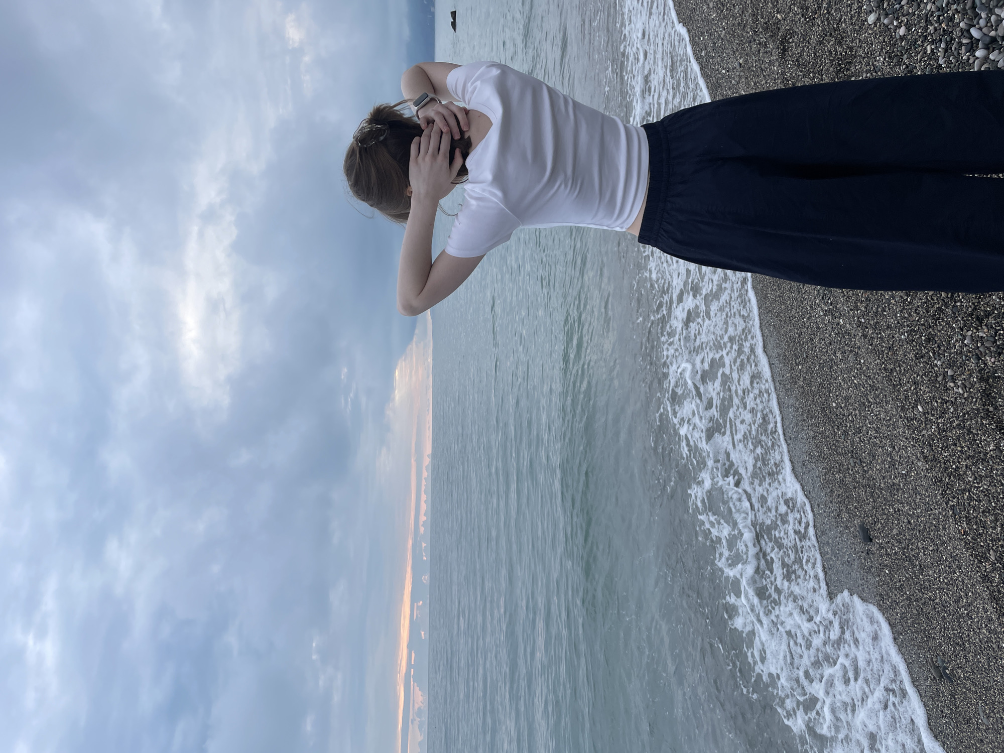 Beachgoers photographed on Gagra pebble beach during cloudy afternoon