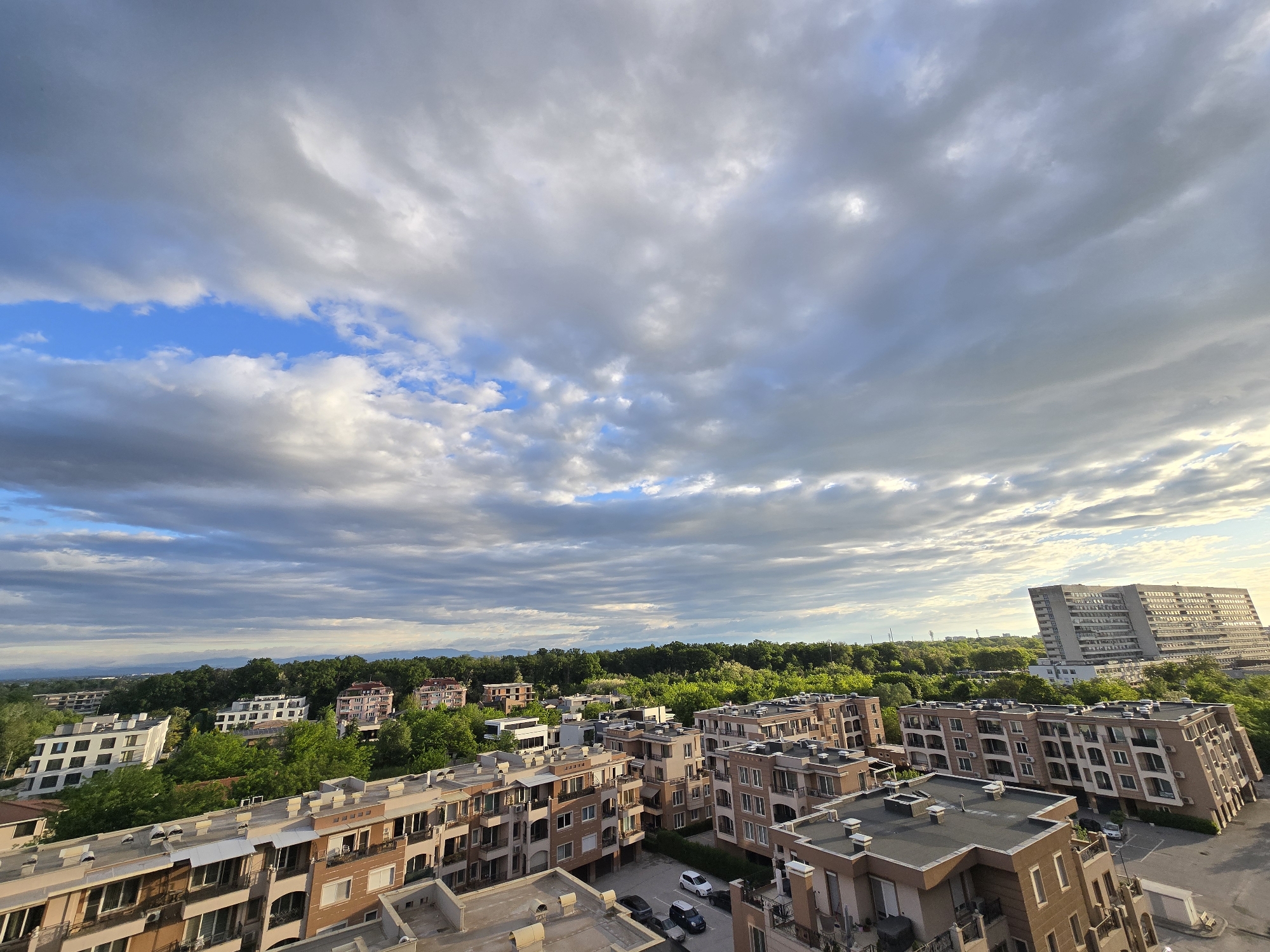 Residential cityscape observed under dramatic cloudy skies