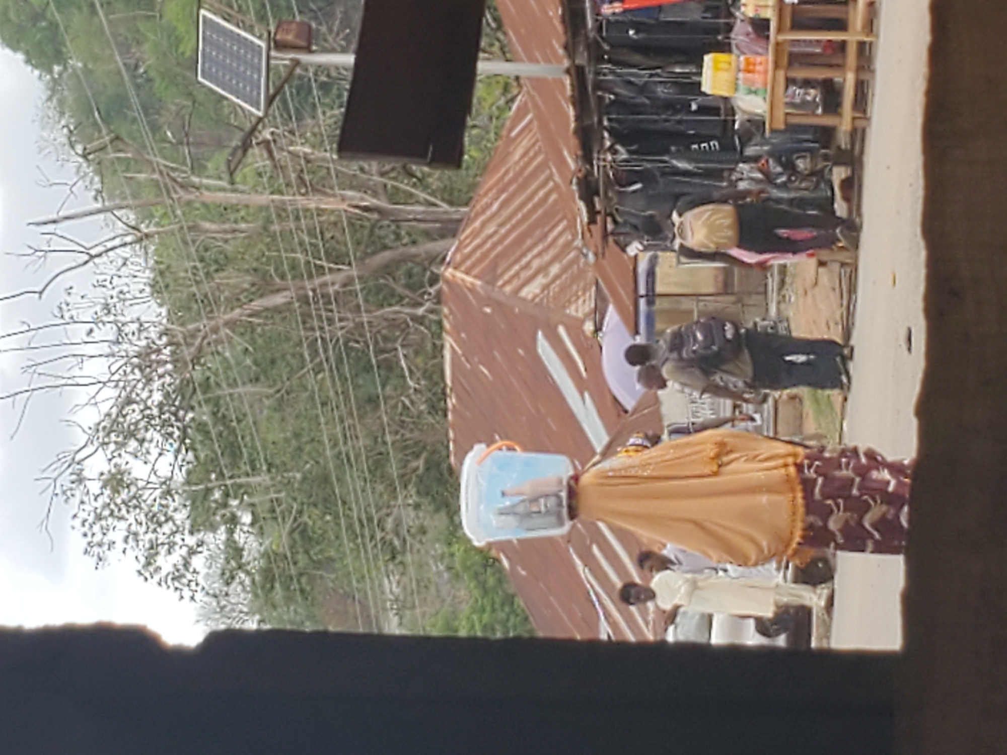 Person carries container on head in urban setting