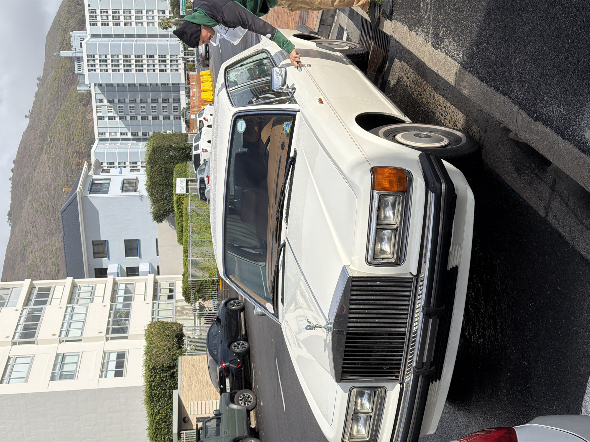 Person enters white Rolls-Royce on Cape Town street