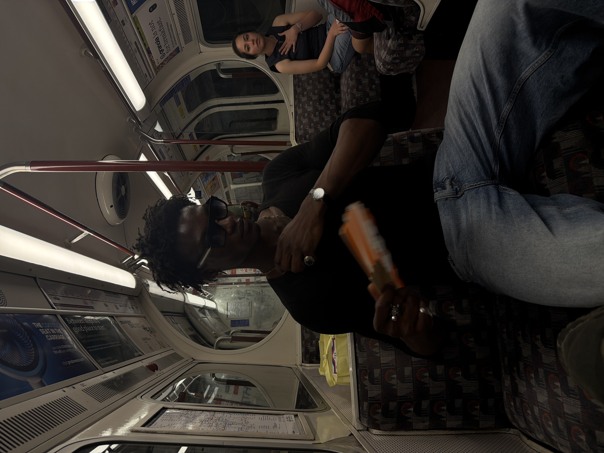 Two riders on a dimly lit subway car