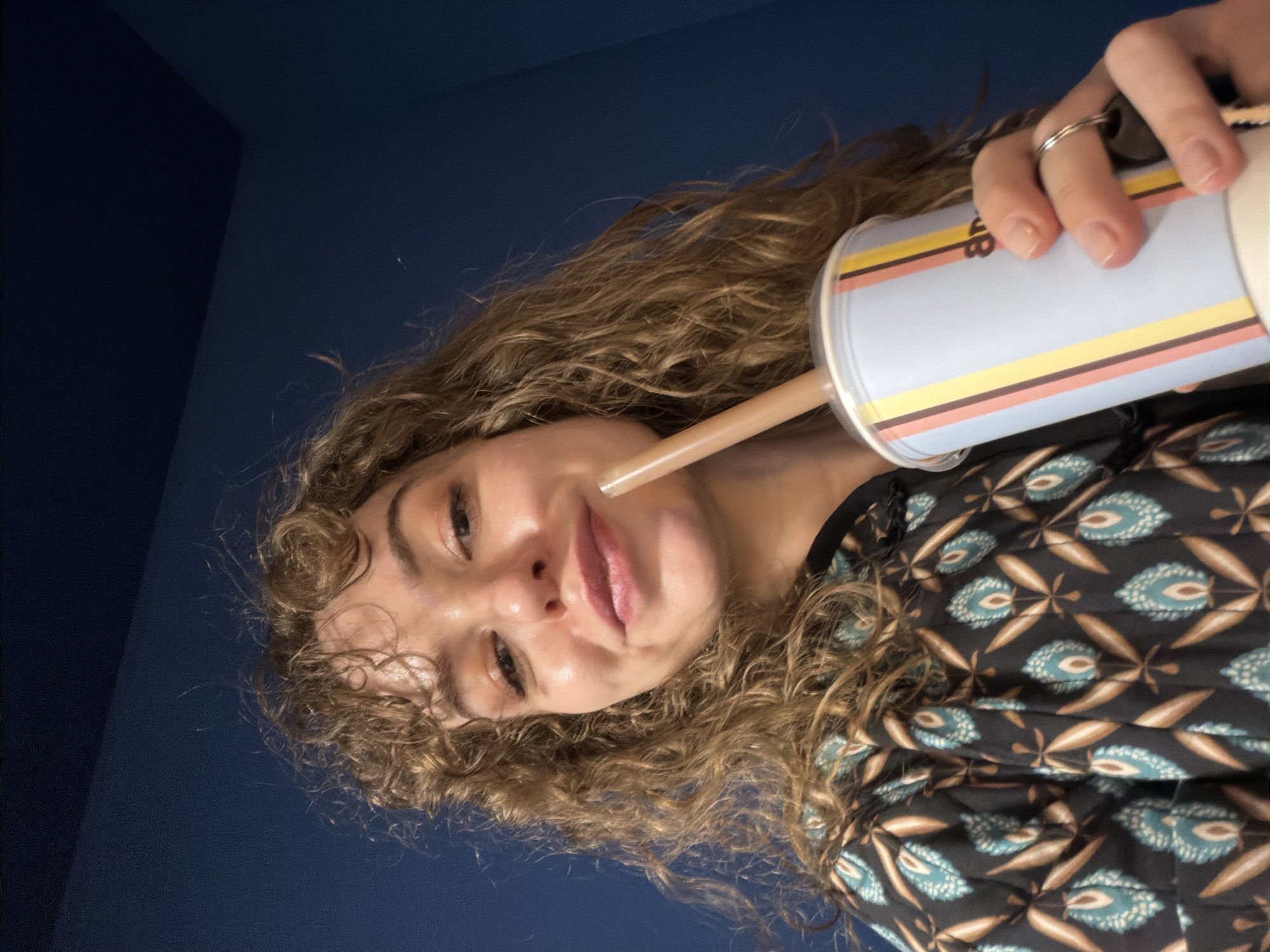 Woman drinks from striped cup in Moscow indoor setting