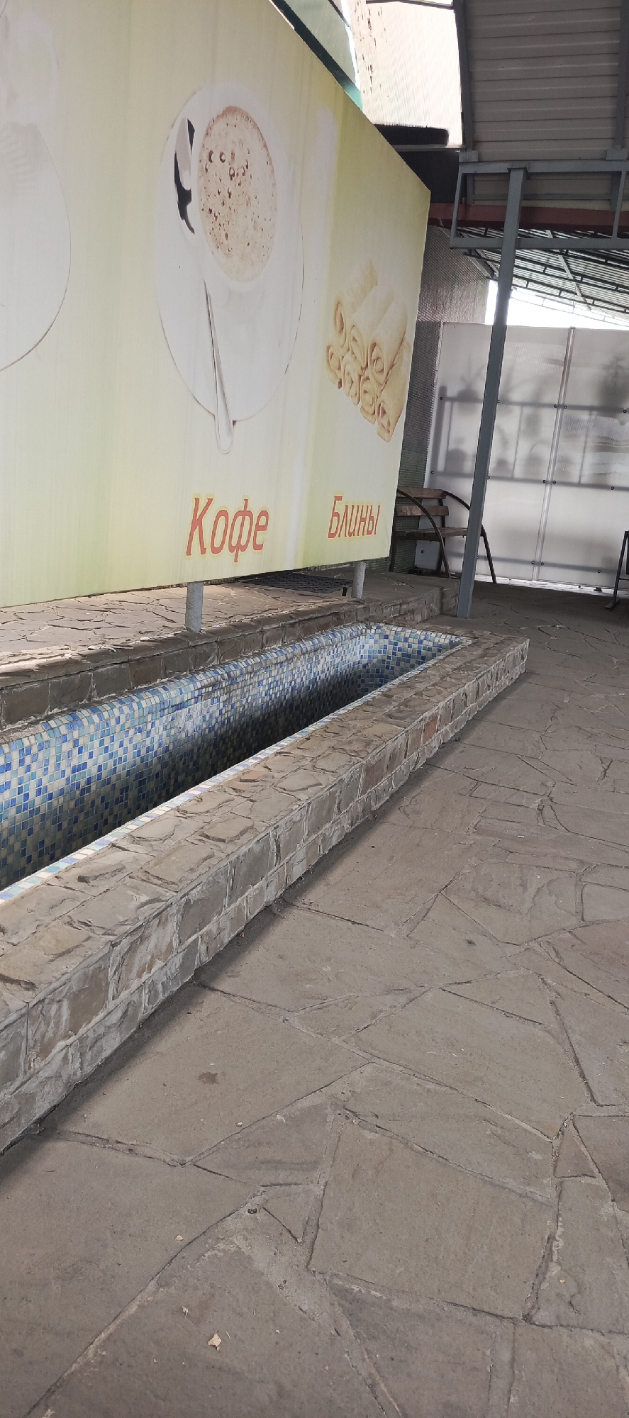 Tiled water feature and covered seating in Kamenolomni plaza