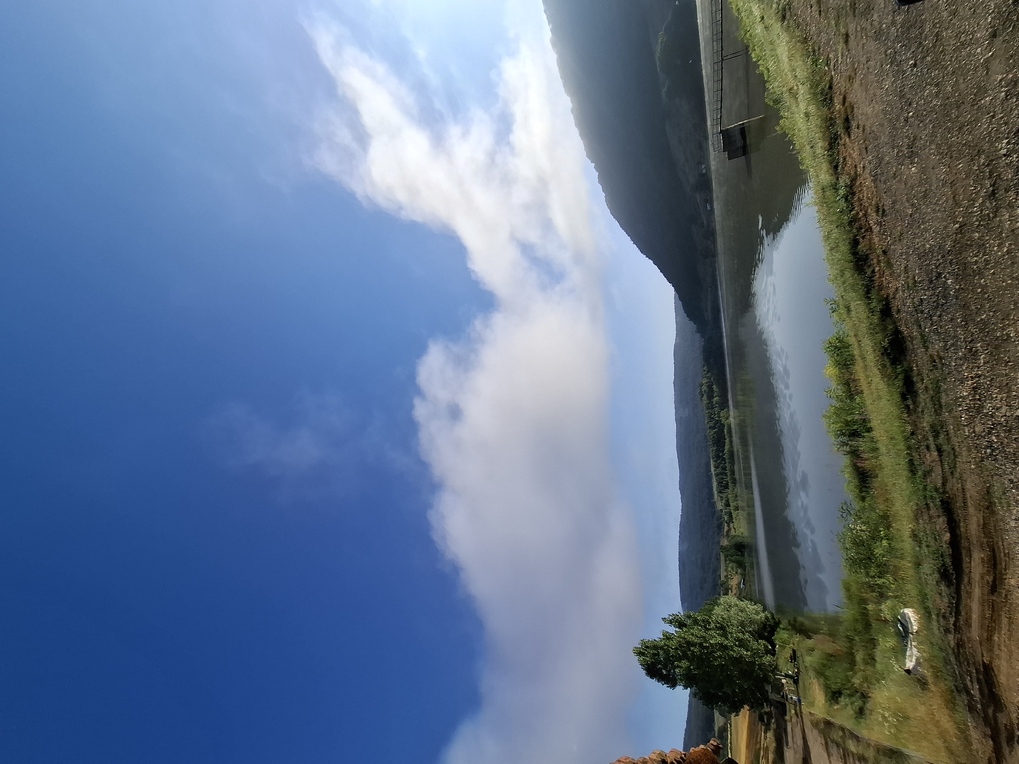 Calm reservoir under a cloud-scattered sky in rural Bulgaria