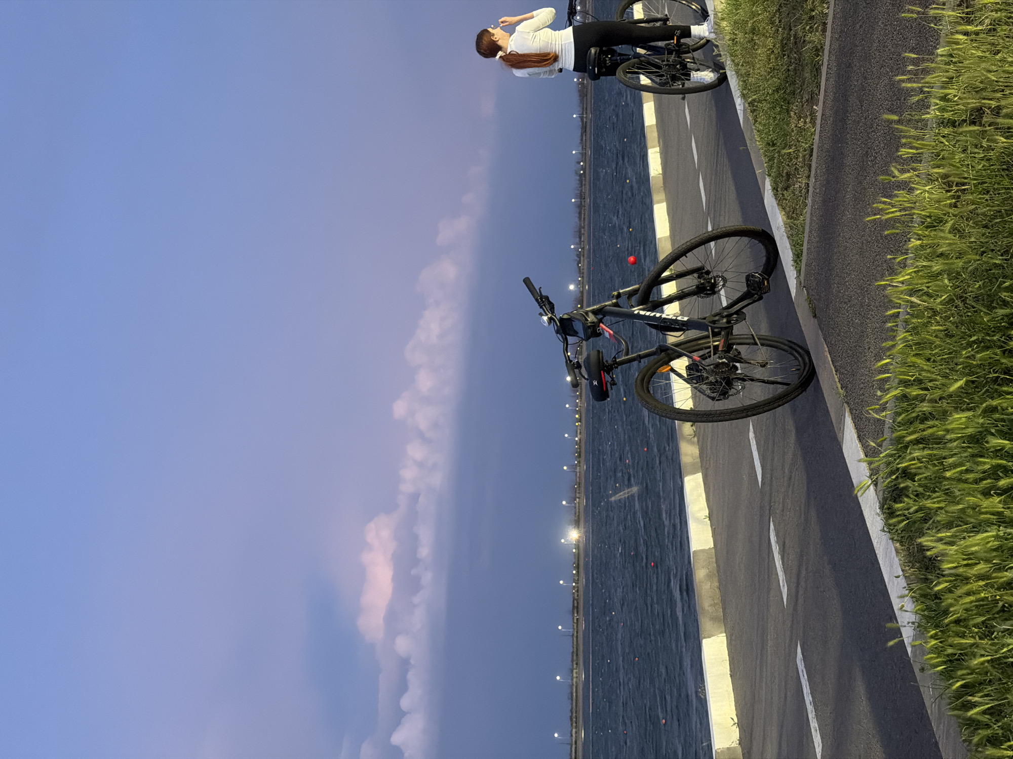 Woman with bicycles observed on waterfront path in Rostov-on-Don
