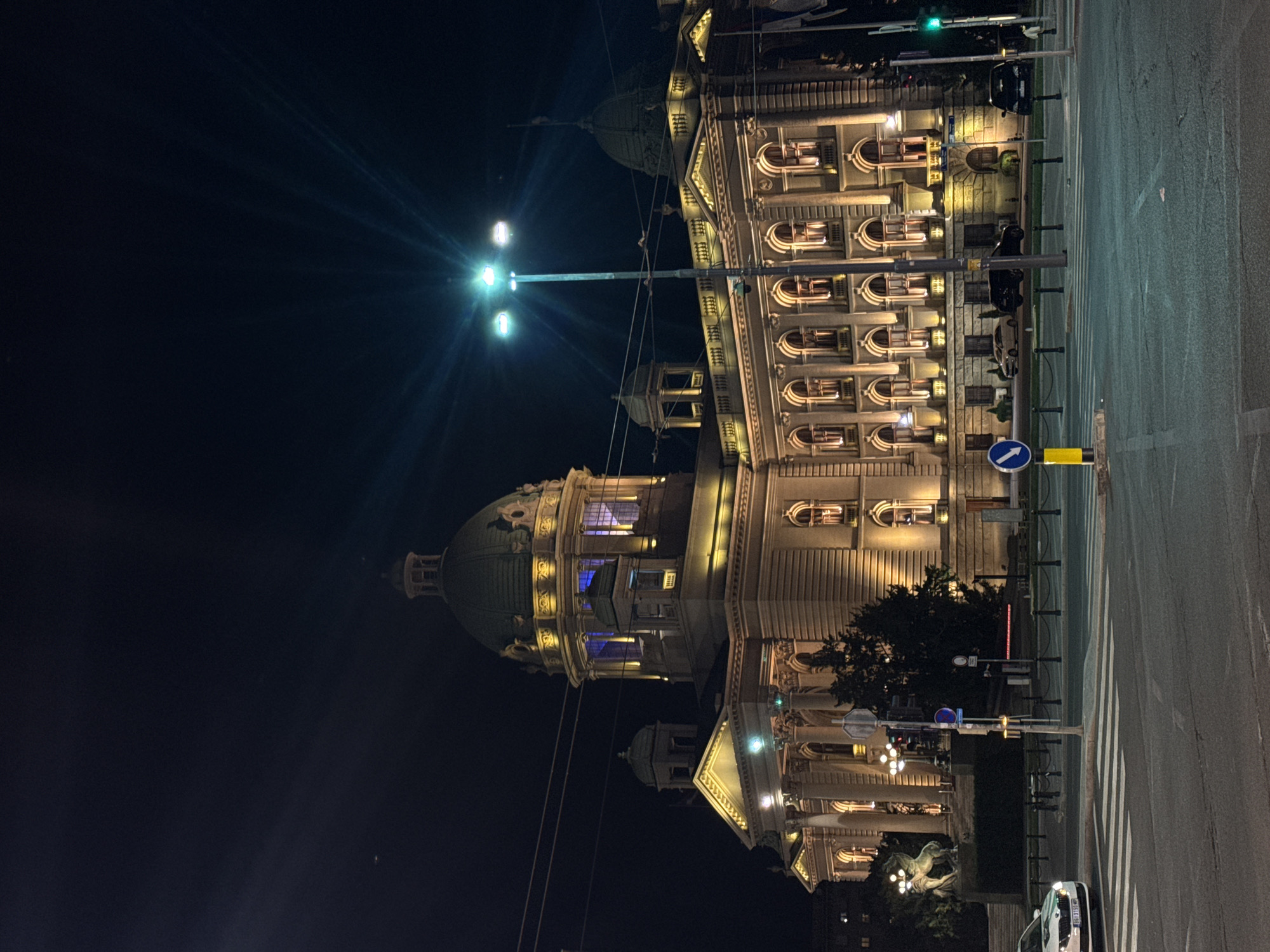 Nighttime pedestrian crossing captured near illuminated Serbian National Assembly