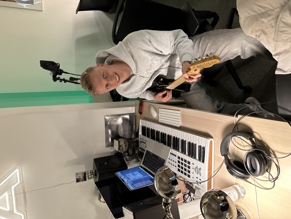 Musician records with electric guitar in London studio