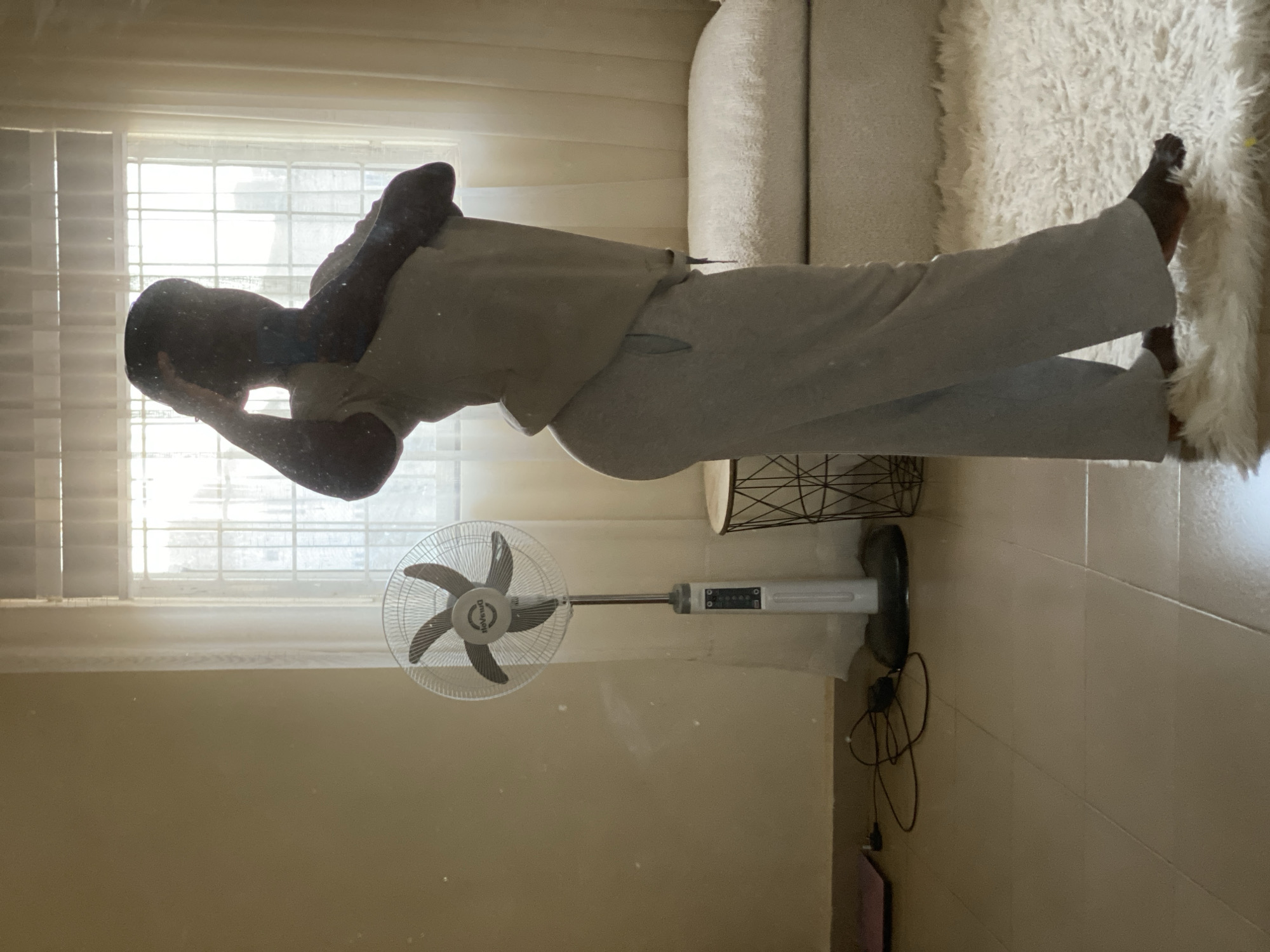 Person rests on couch in Nigerian home setting