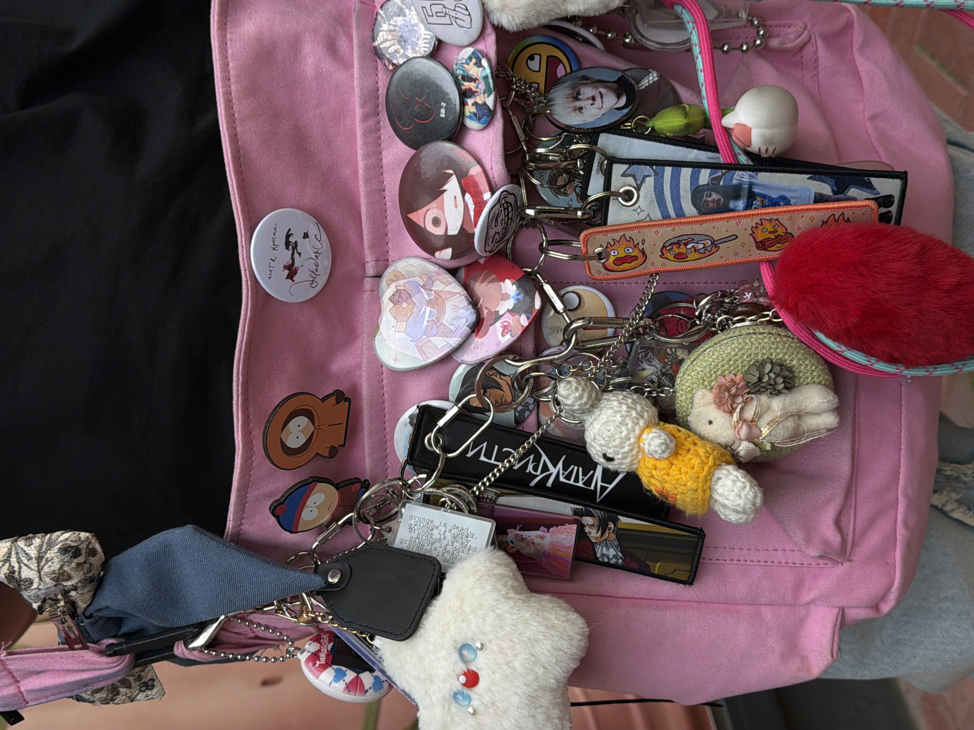 Decorated pink backpack spotted with anime pins in Budva