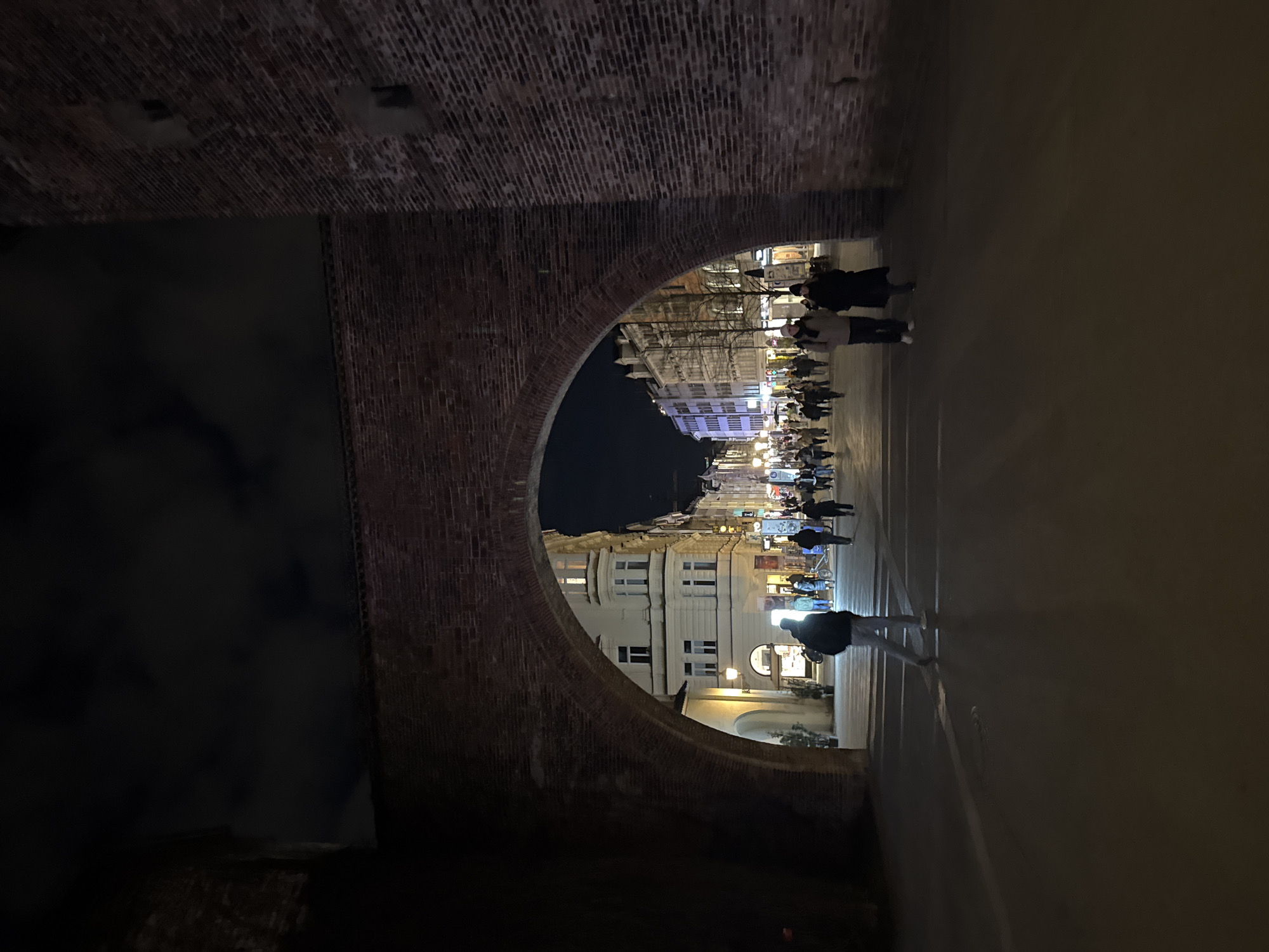 Munich's Karlstor archway frames nighttime pedestrian street scenes