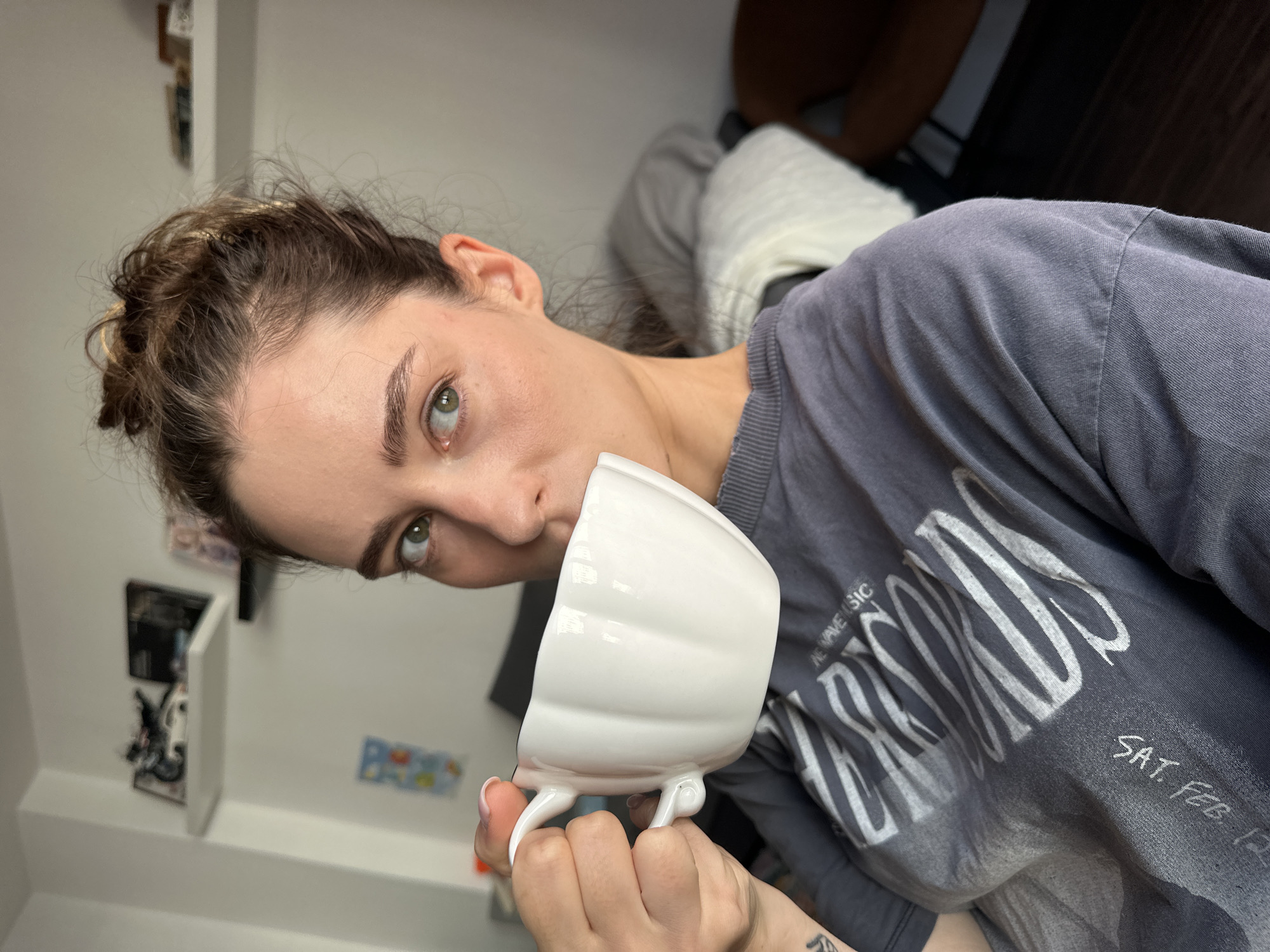 Woman in grey band shirt observed indoors in Kiel