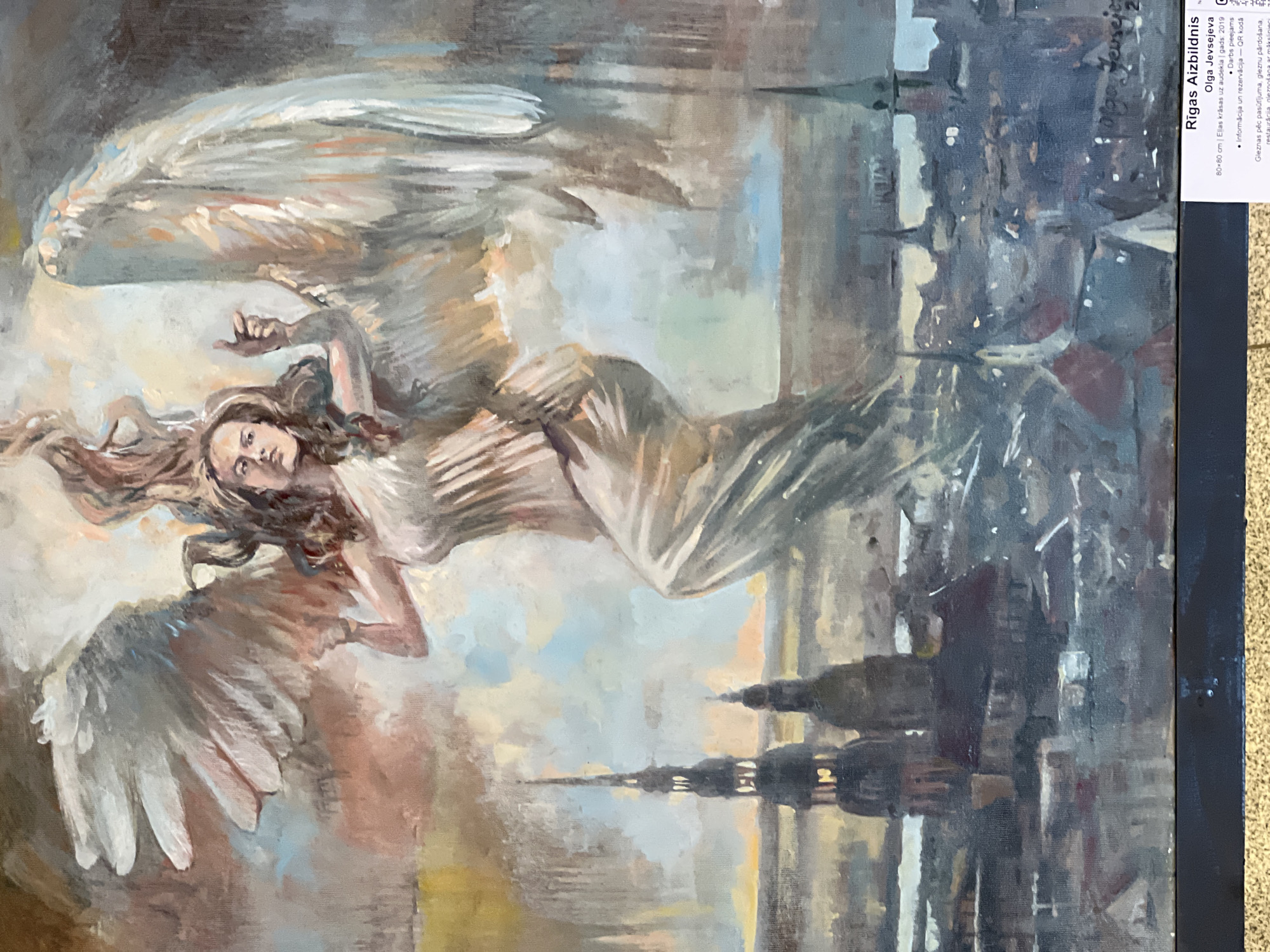 Visitor documents art and antique displays in Riga cultural venue