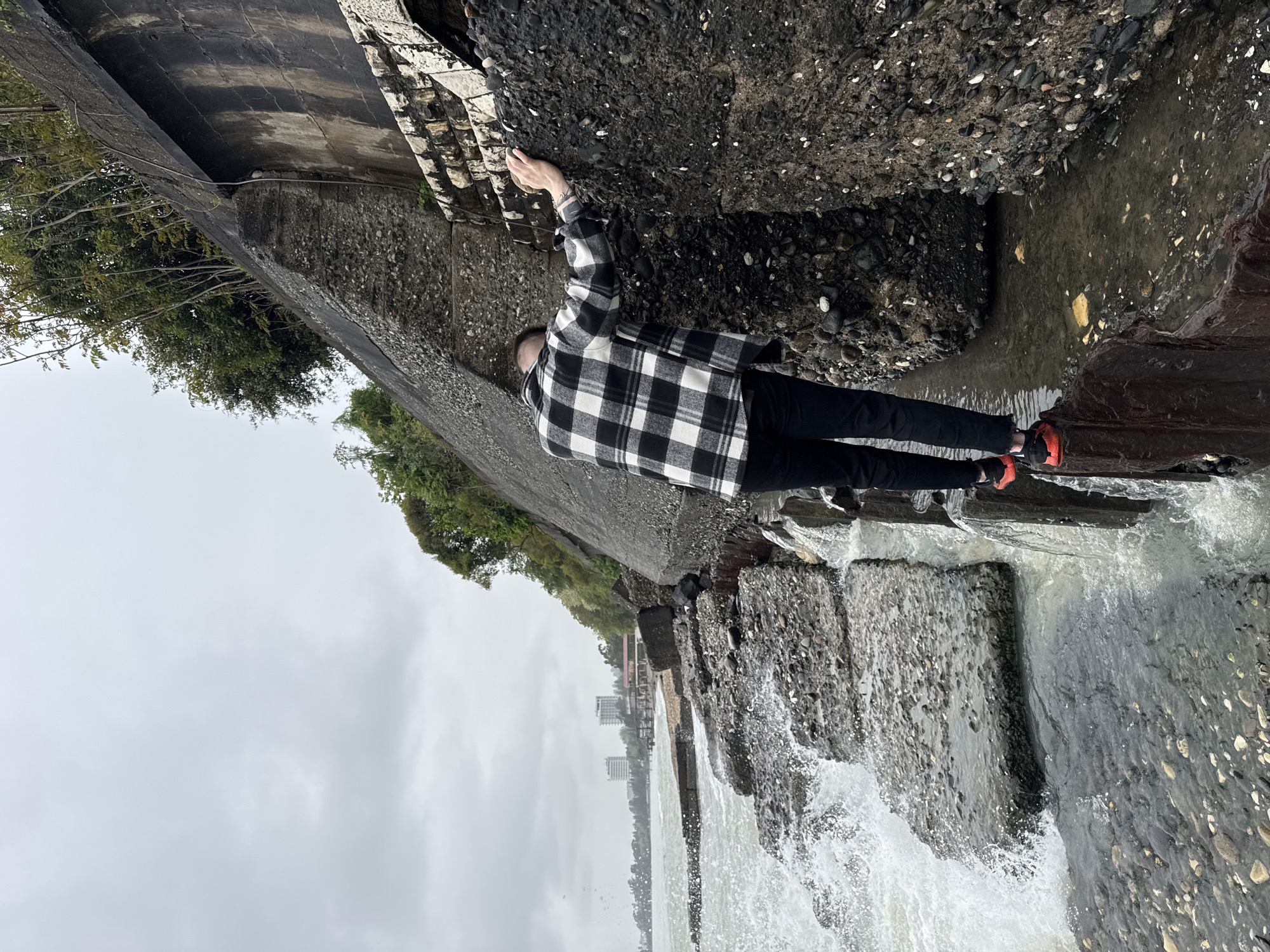 Visitors navigate rocky Black Sea coastline amid crashing waves