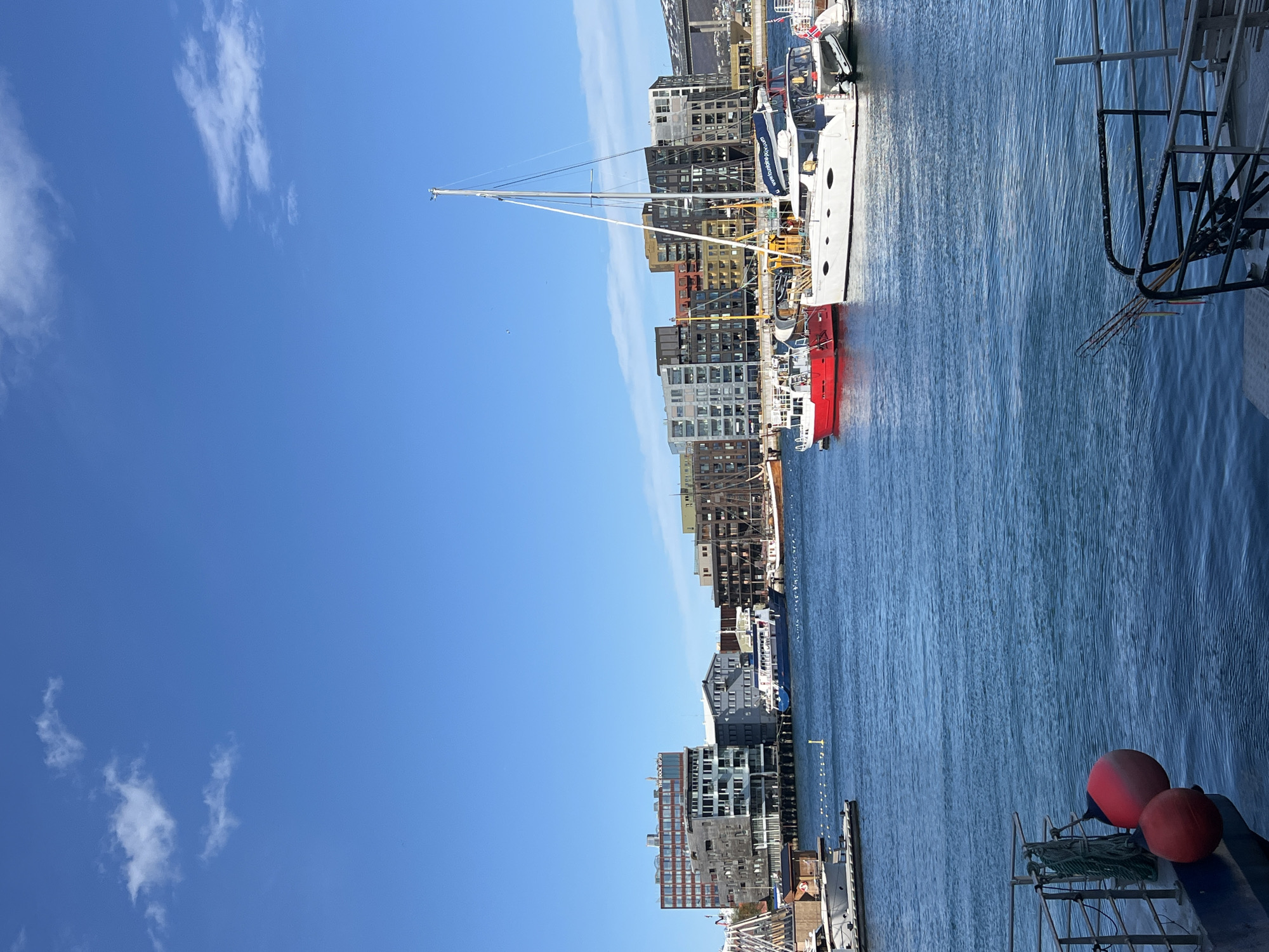 Clear afternoon at Tromsø harbor with boats, mountains visible