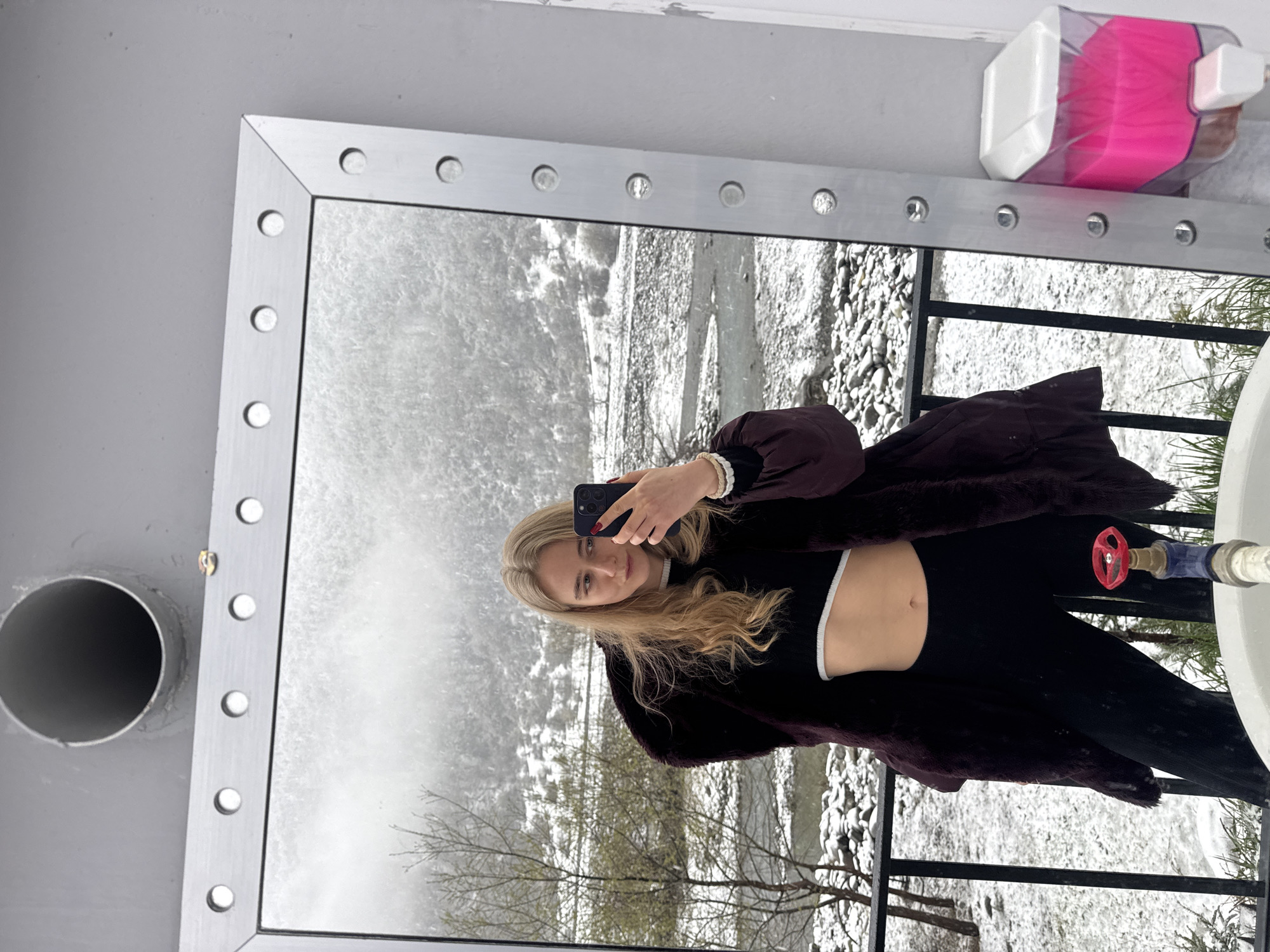 Woman takes winter selfies on snowy mountain balcony