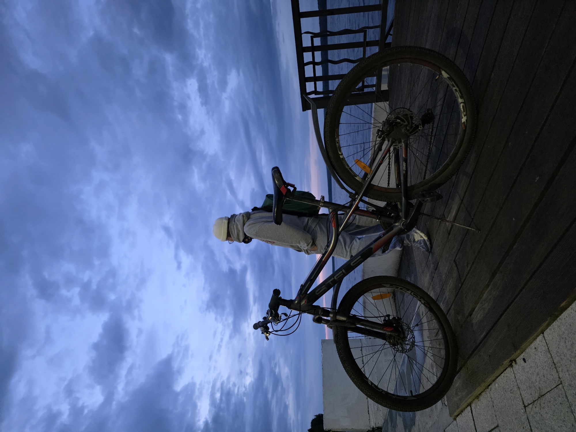 Woman with bike visits Kama River waterfront in Chaikovsky