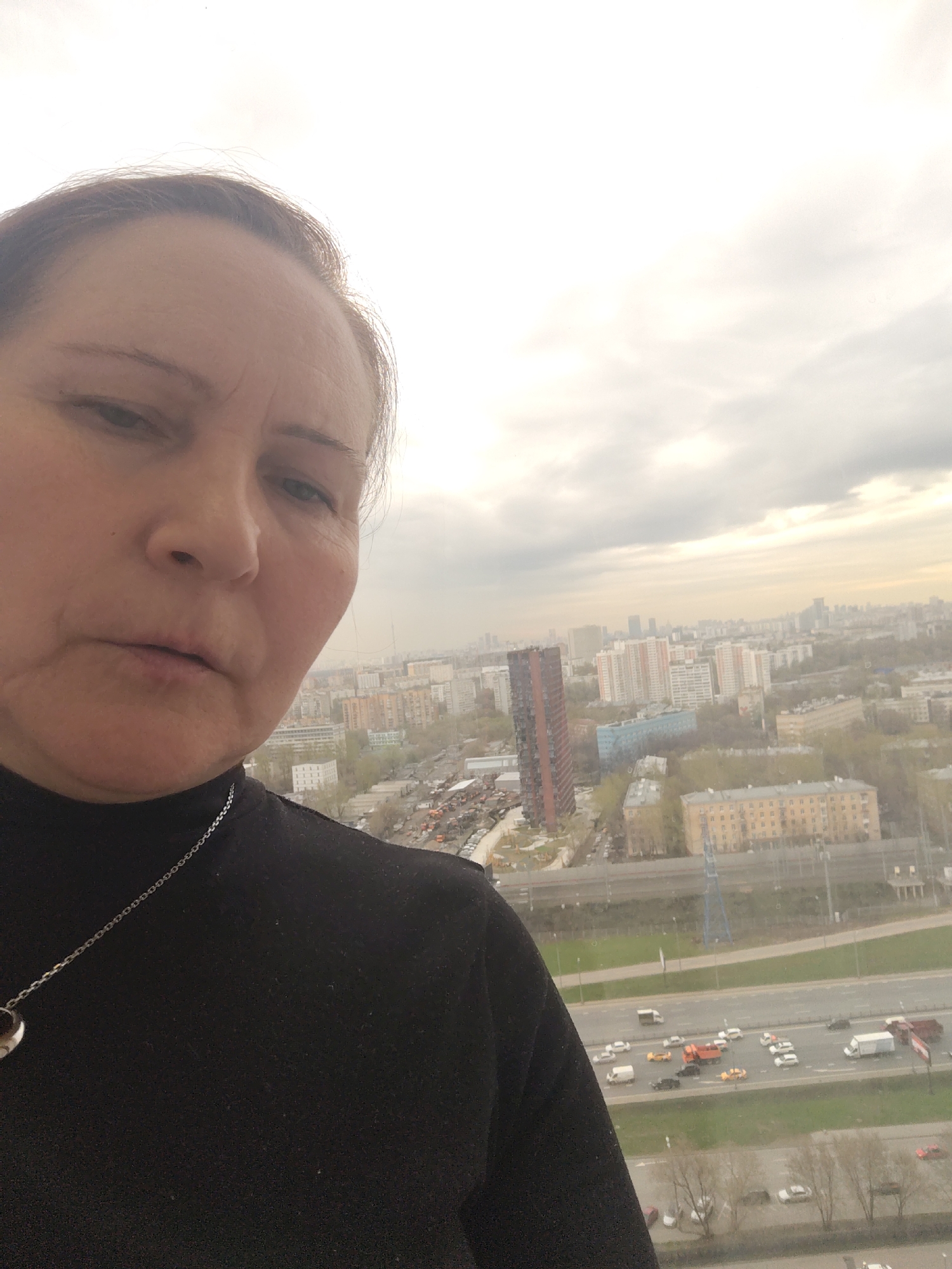 Woman Takes Selfie Overlooking City During Overcast Afternoon