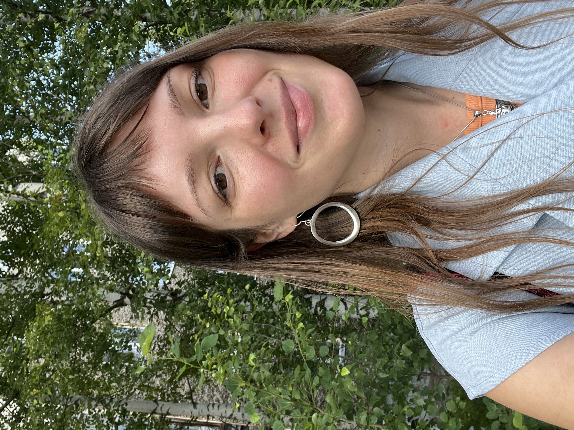 Smiling outdoors in Gubakha, Russia, light blue jacket