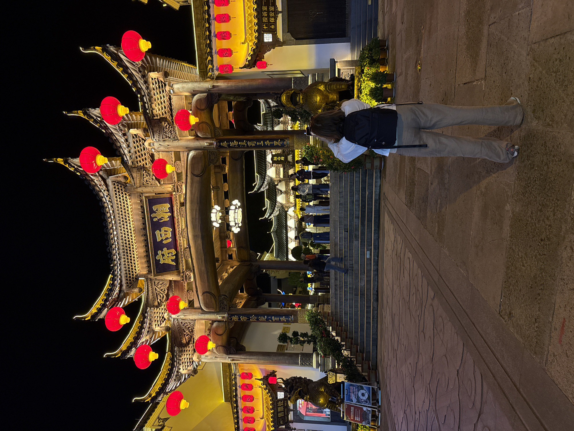 Night crowds gather at illuminated traditional architecture in Wulingyuan