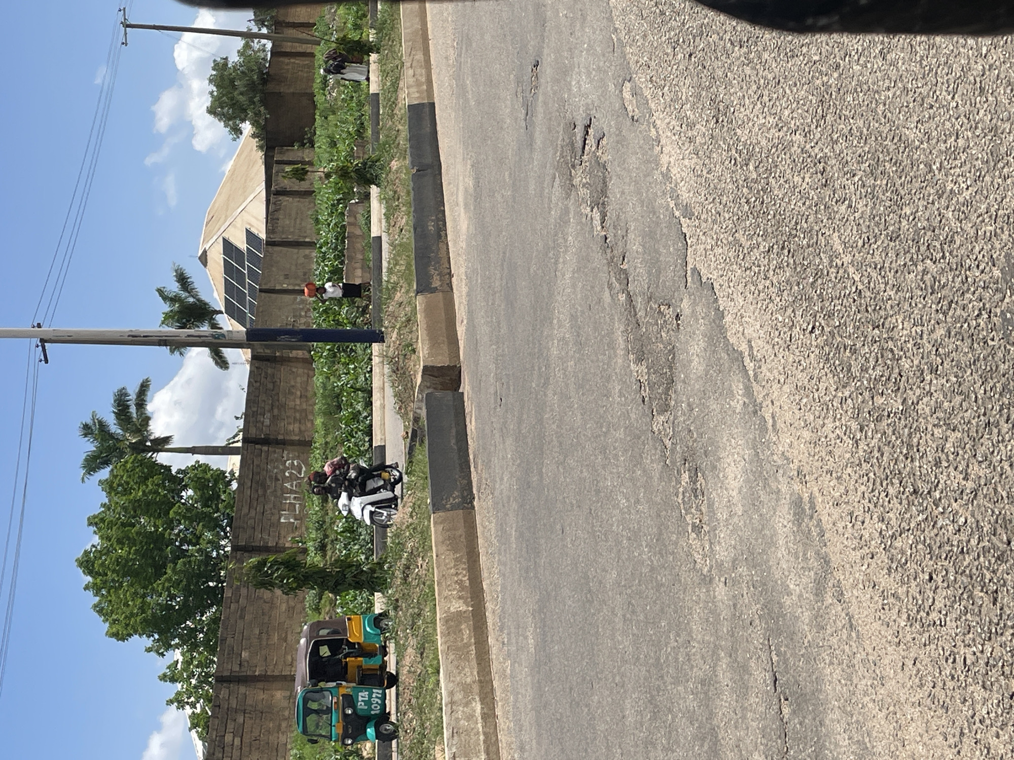 Street-level ride through Bukuru, passing shops and roadside activity