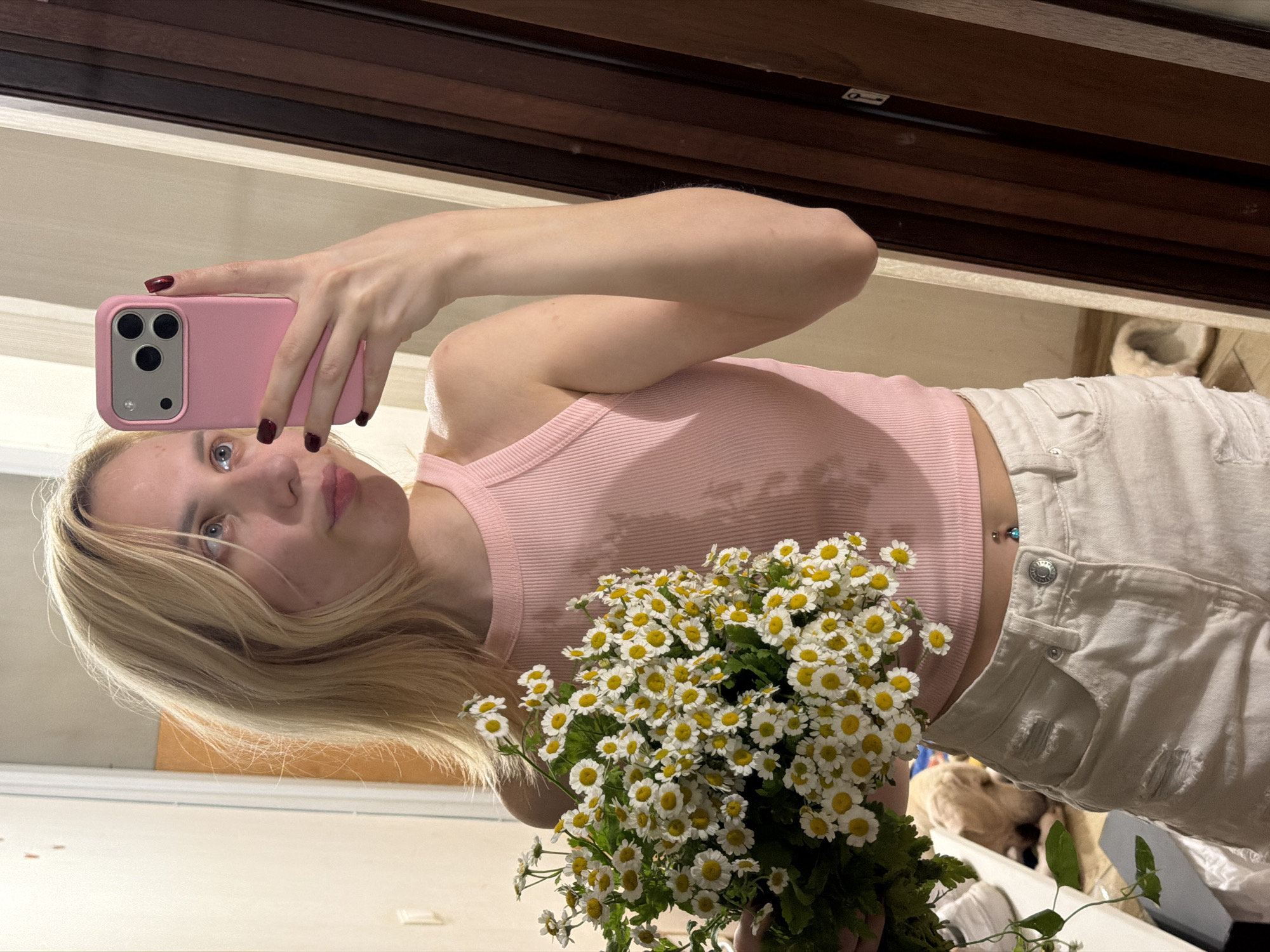 Mirror selfie with white daisy bouquet in Moldovan home