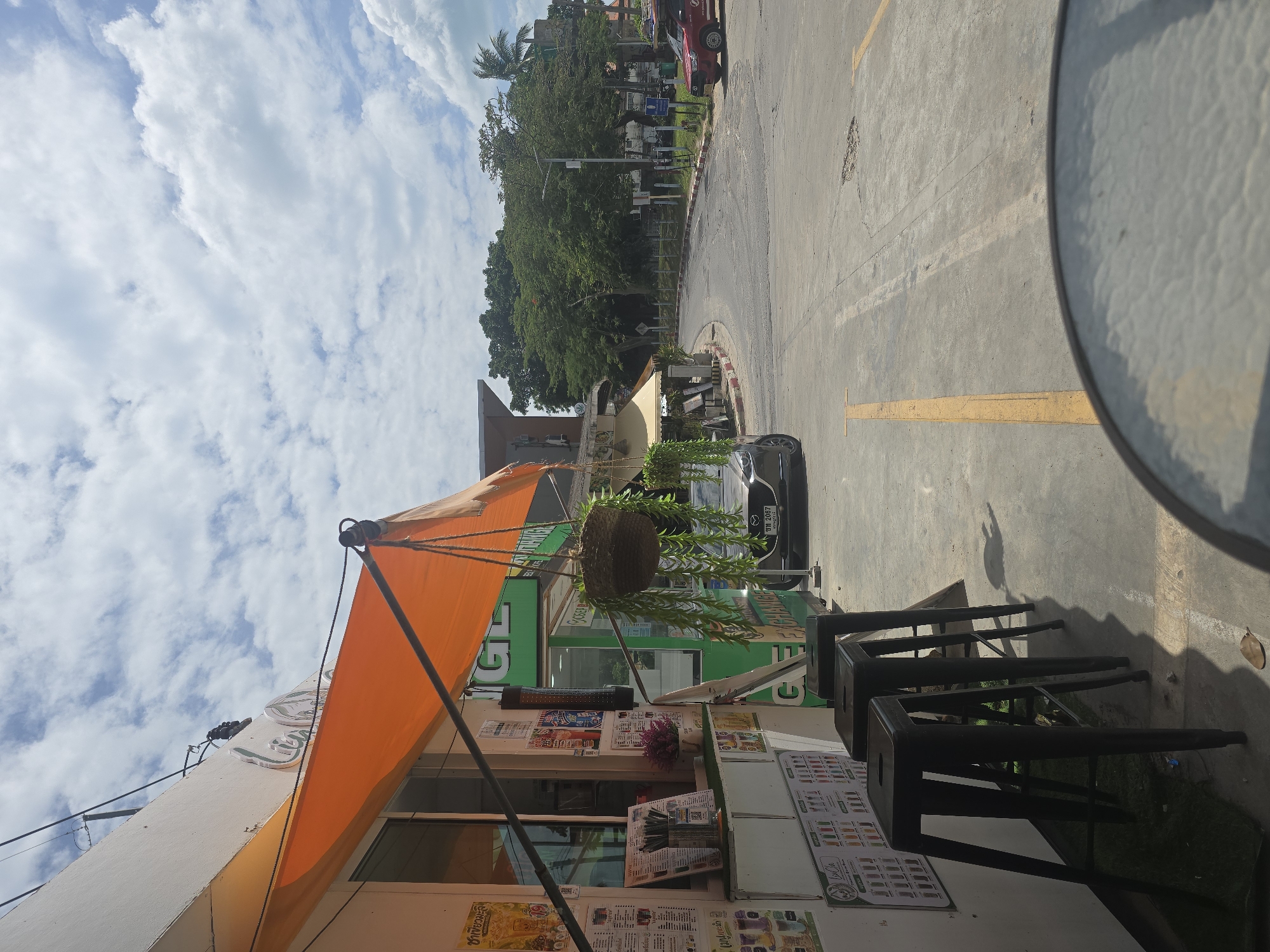 Busy Thai tourist street: scooters, kiosks, and everyday traffic