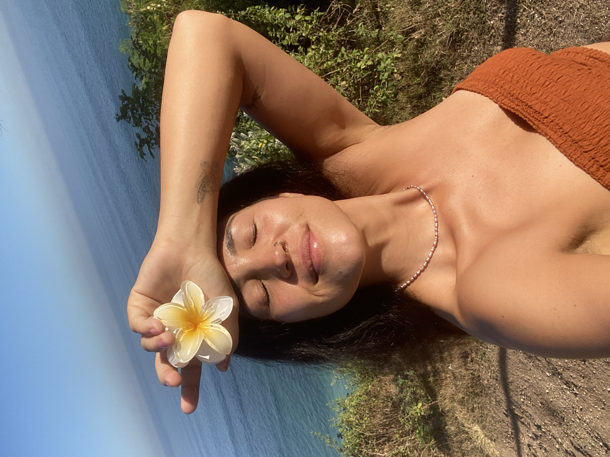 Flower ritual and coastal views from a Bali hillside