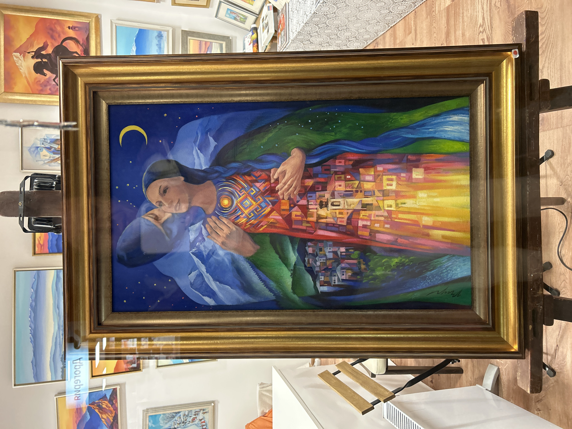 Mountain landscape painting with woman displayed on easel in Bansko