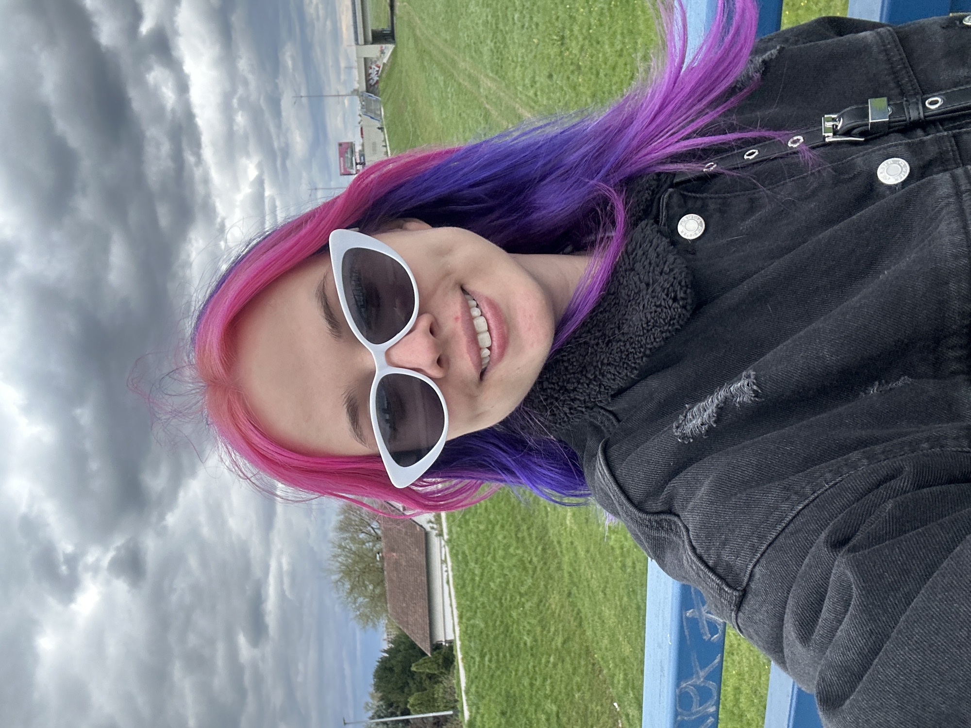 Colorful-haired person poses in Zagreb field setting
