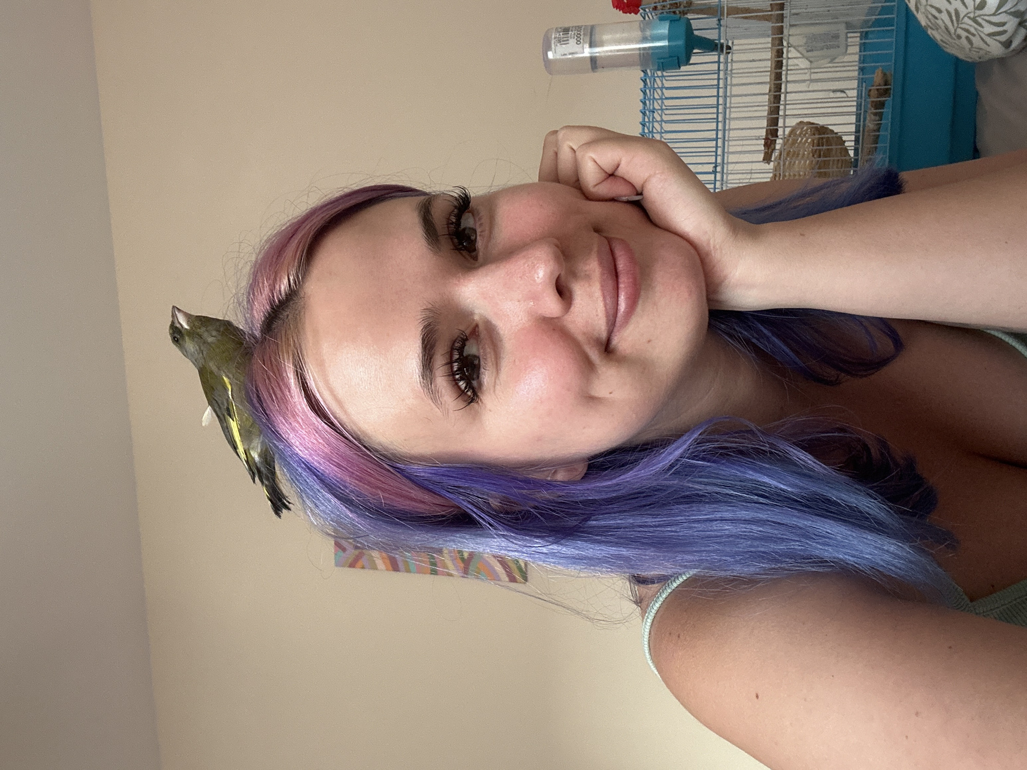 Woman with colorful hair enjoys churros with pet bird in Gijón