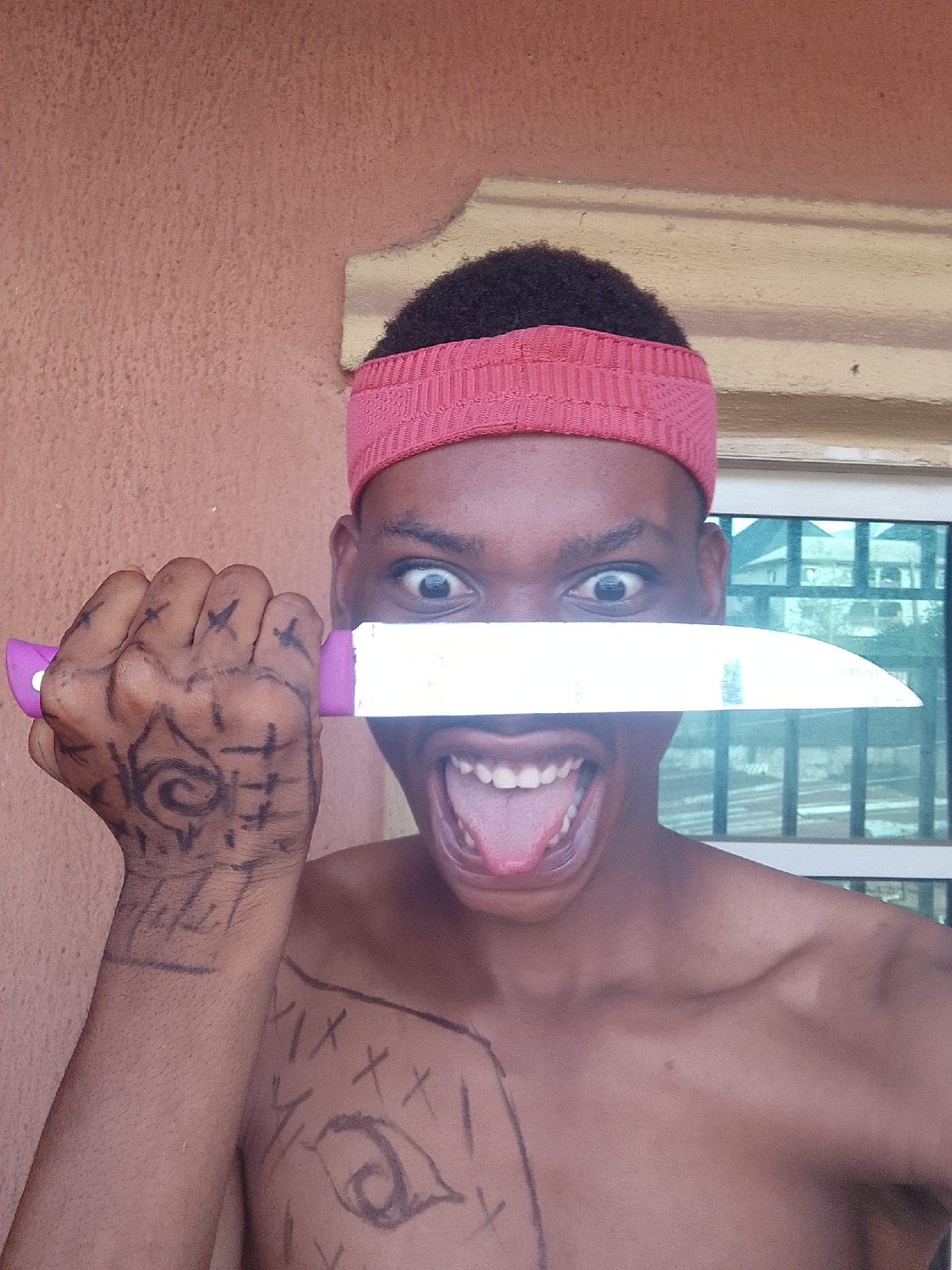 Young man performs knife demonstration with body markings