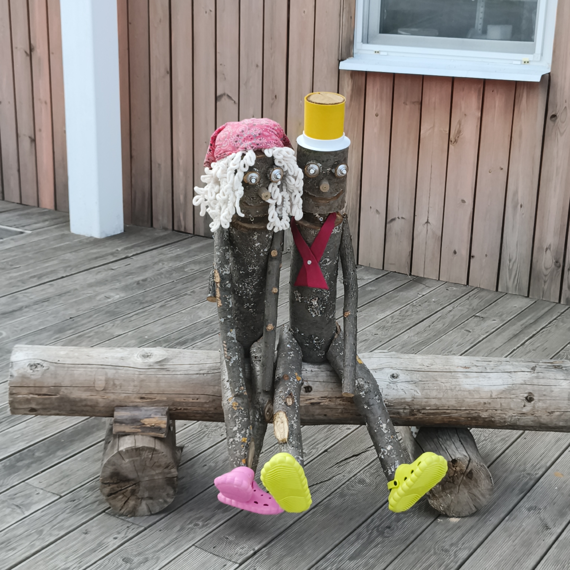 Handmade wooden folk art figures on a bench in Chaikovsky