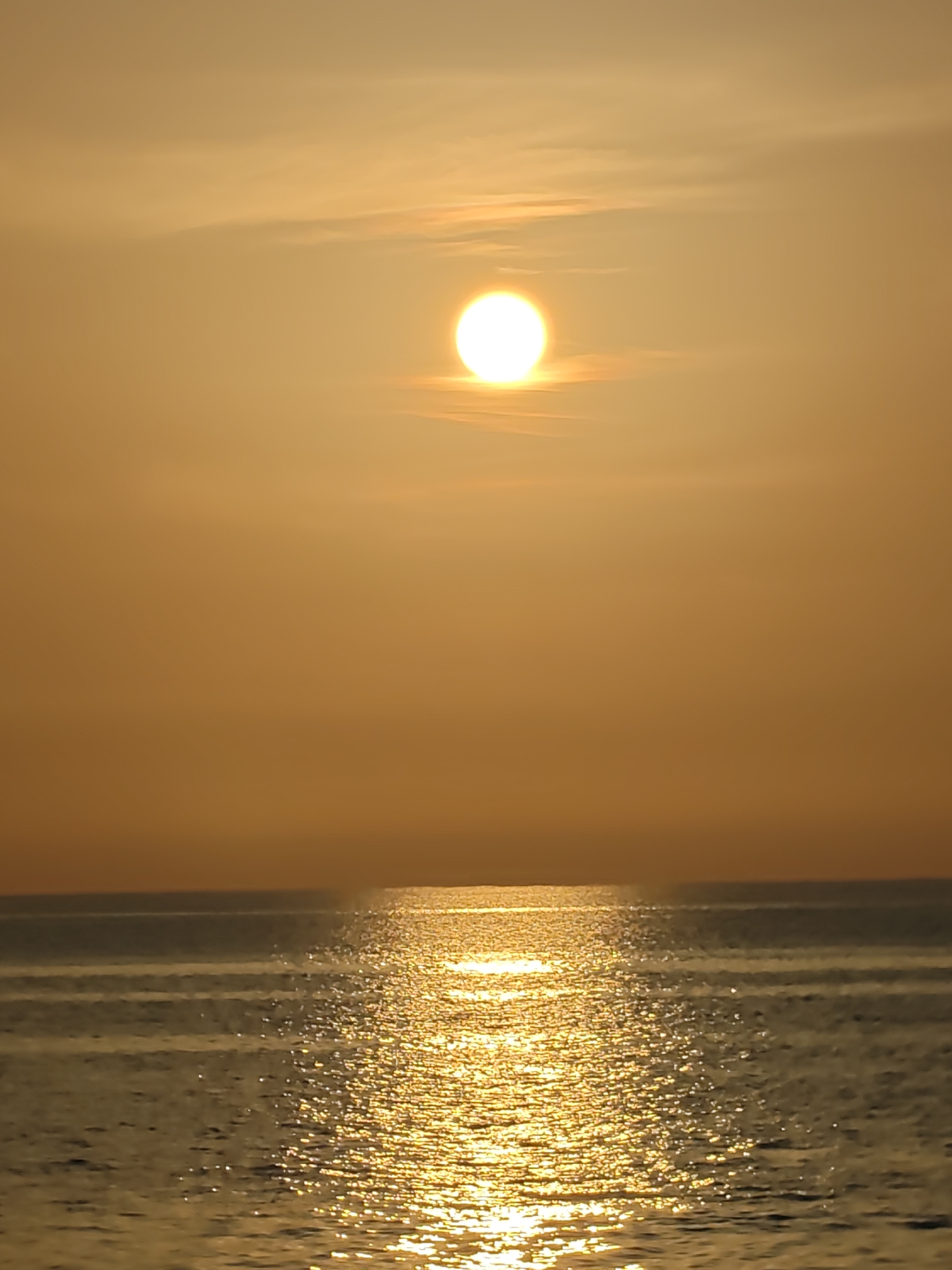 Golden sunset over the Lhokseumawe coast, fishing boat in silhouette