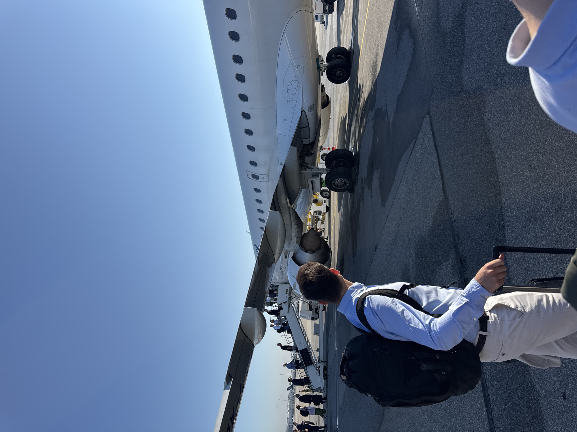 Boarding via mobile stairs on a sunny Oberding tarmac.