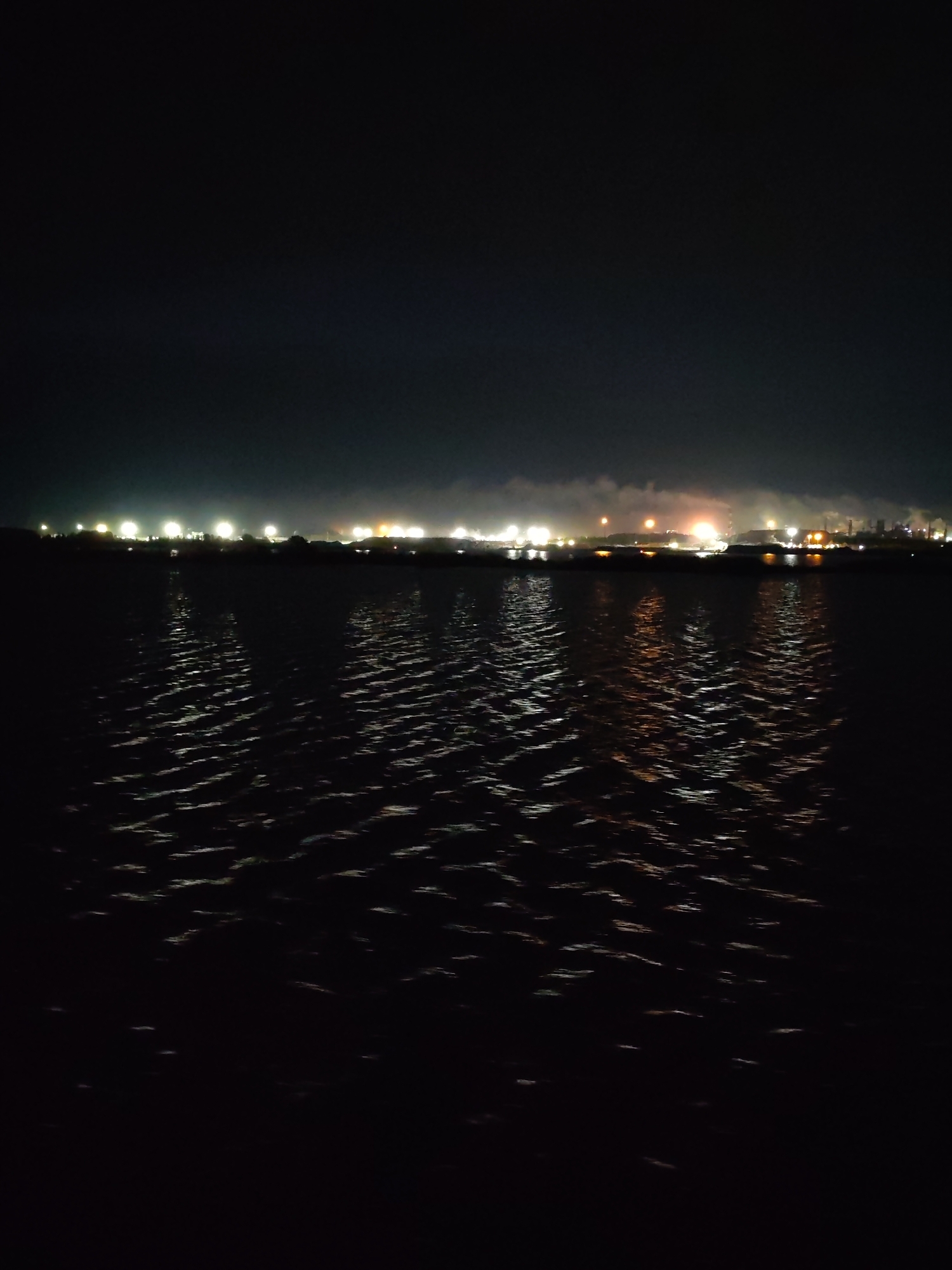 Nighttime industrial waterfront lights captured across 48-minute span
